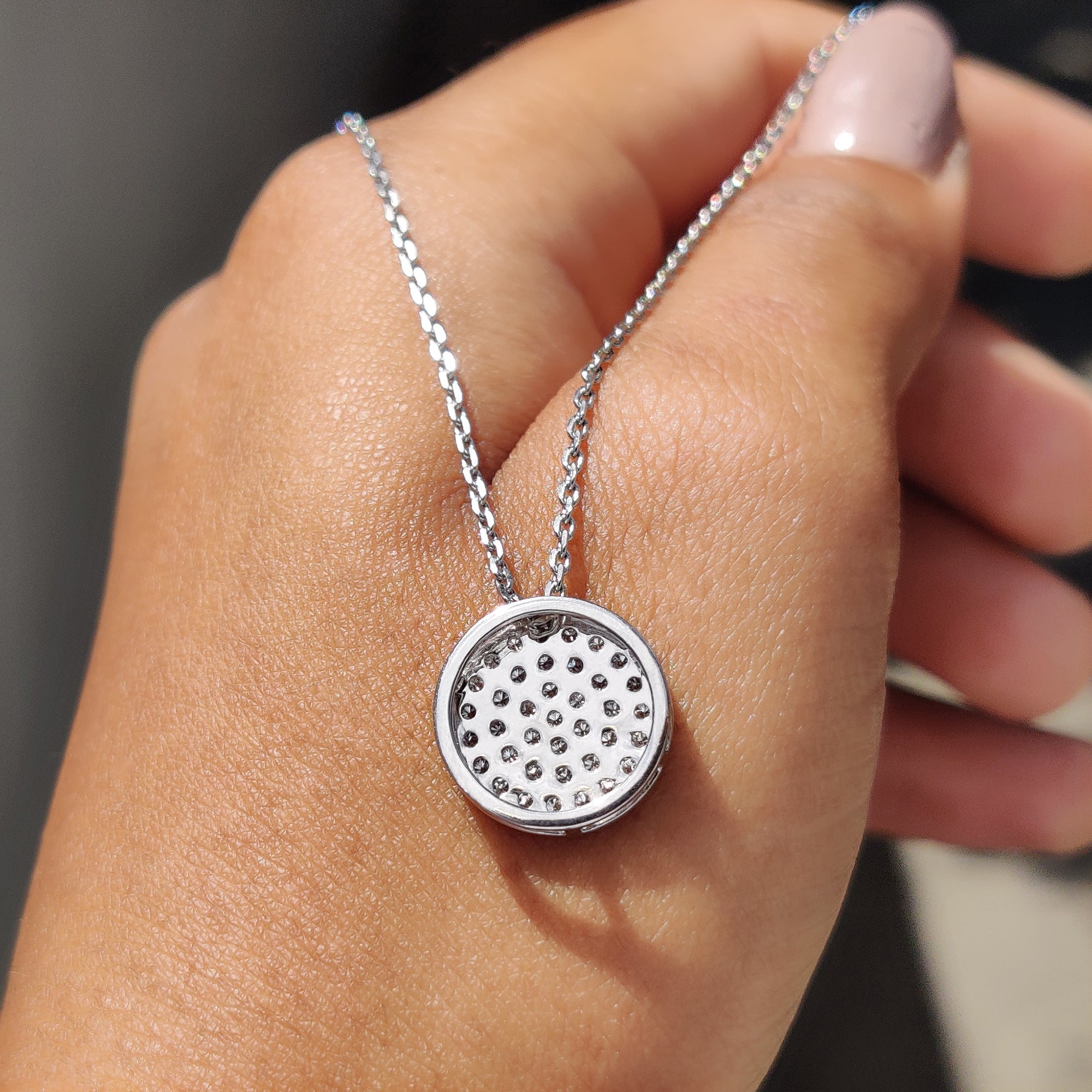 Round diamond cluster pendant set in a white gold frame.
