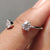 Open gap wedding band featuring two round cut moissanite stones in a modern prong setting.