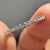 Round cut wedding band featuring moissanite stones set in a clean and secure prong setting.
