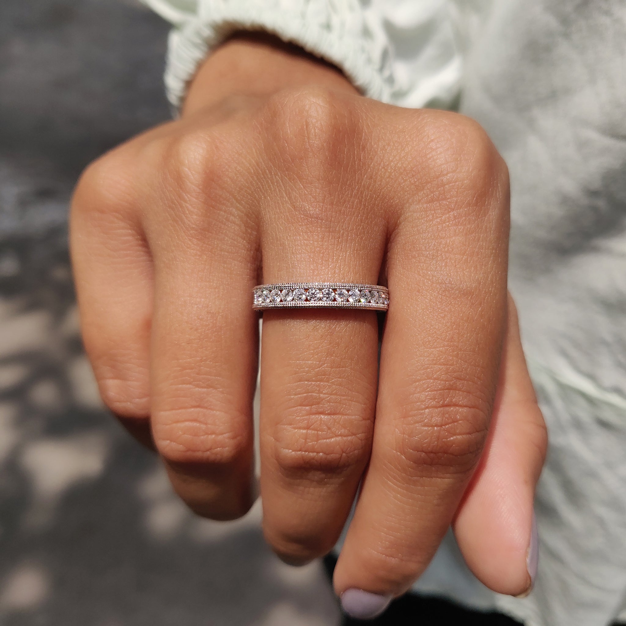 Moissanite wedding band combining Art Deco elements and sparkling round cuts for lasting style.
