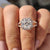 Handmade jewelry featuring a round cut split pave set band and a 4 claw prong setting for a unique engagement ring style.
