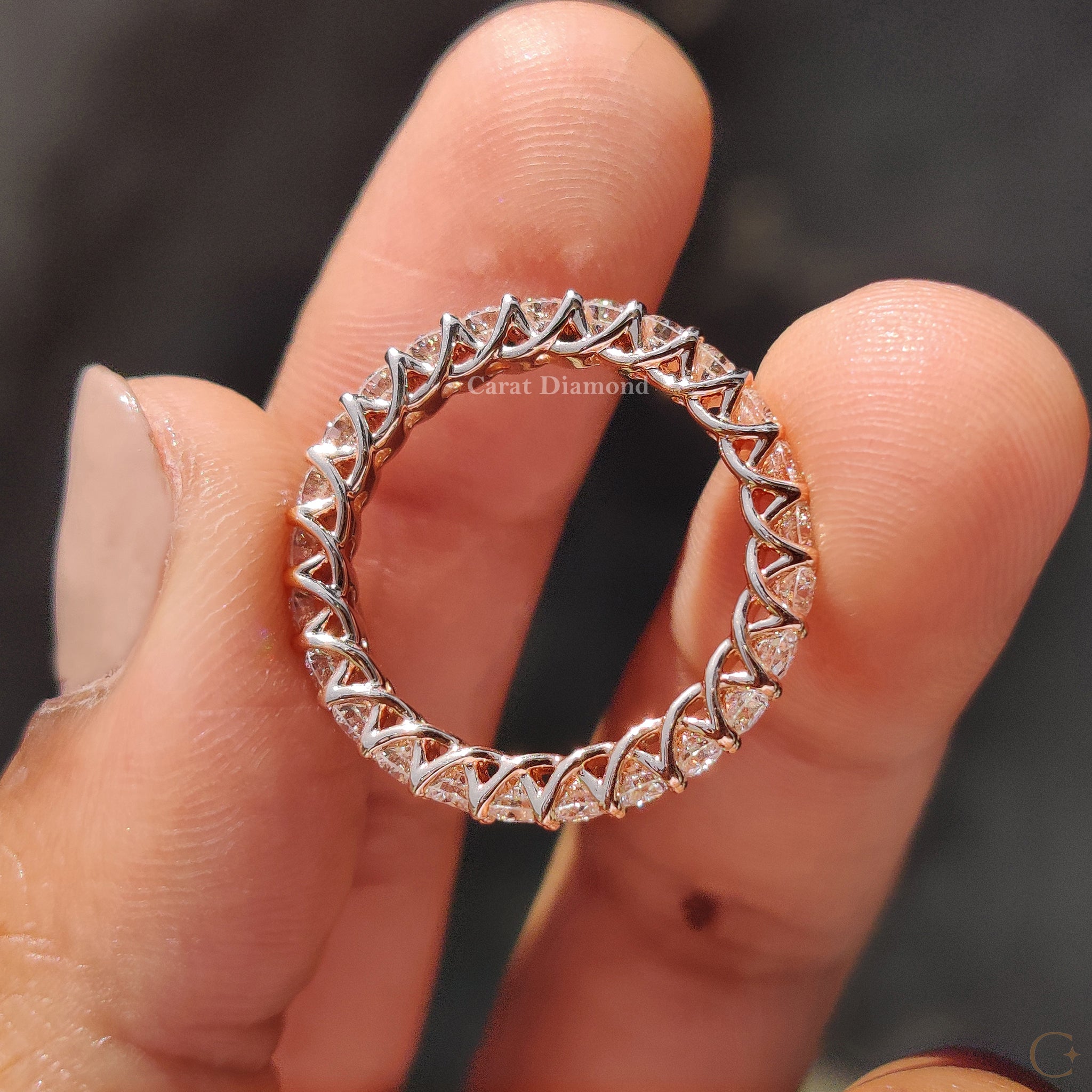 Rose gold wedding band with a delicate design featuring small diamonds.