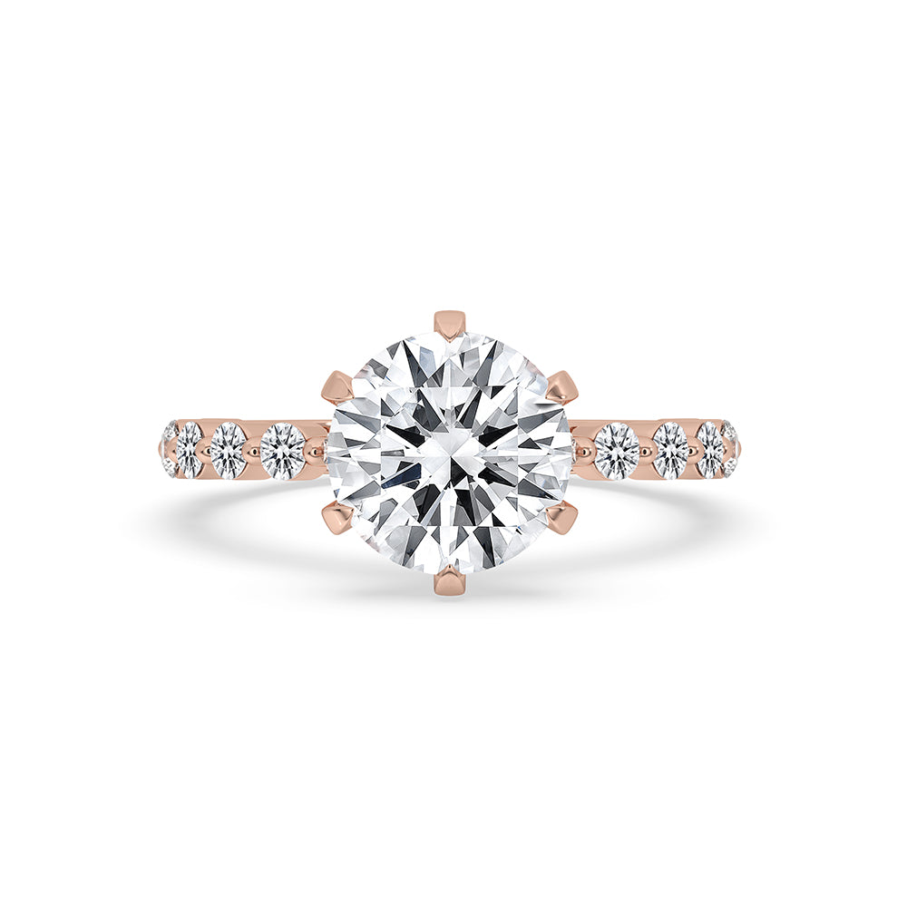 Round cut diamond engagement ring with shared prong band ring in rose gold.
