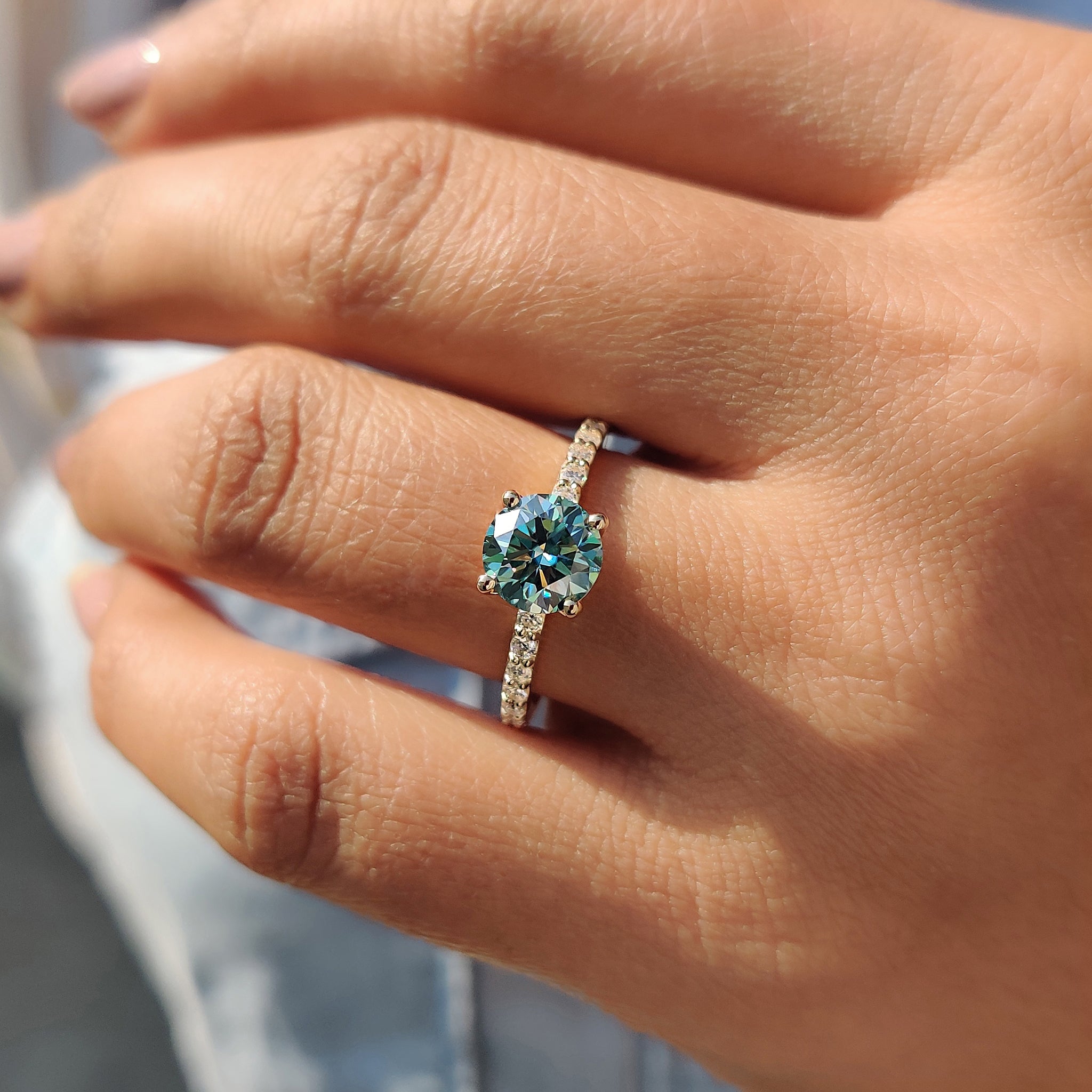 Choose a cyan blue round cut moissanite ring with a yellow gold ring for a fresh, modern twist.
