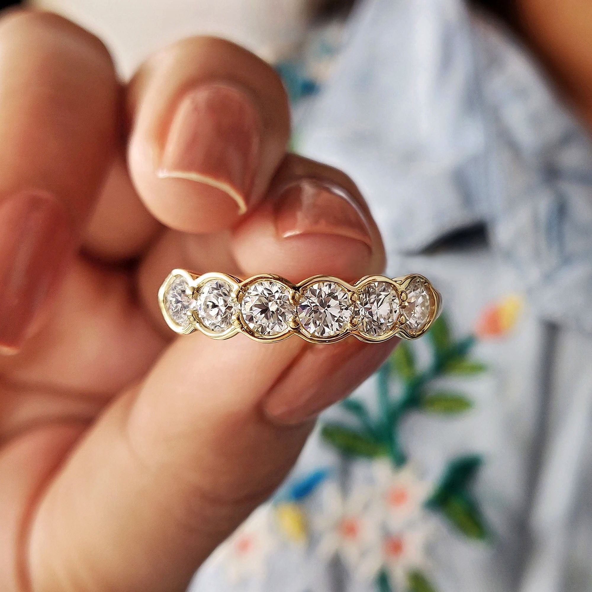 Round Cut Wedding Band featuring bezel set moissanite stones in a handmade band.
