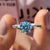 This cyan blue moissanite ring shows off a vibrant hue.