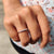 Semi eternity band with round moissanite stones set in a rose gold band design.
