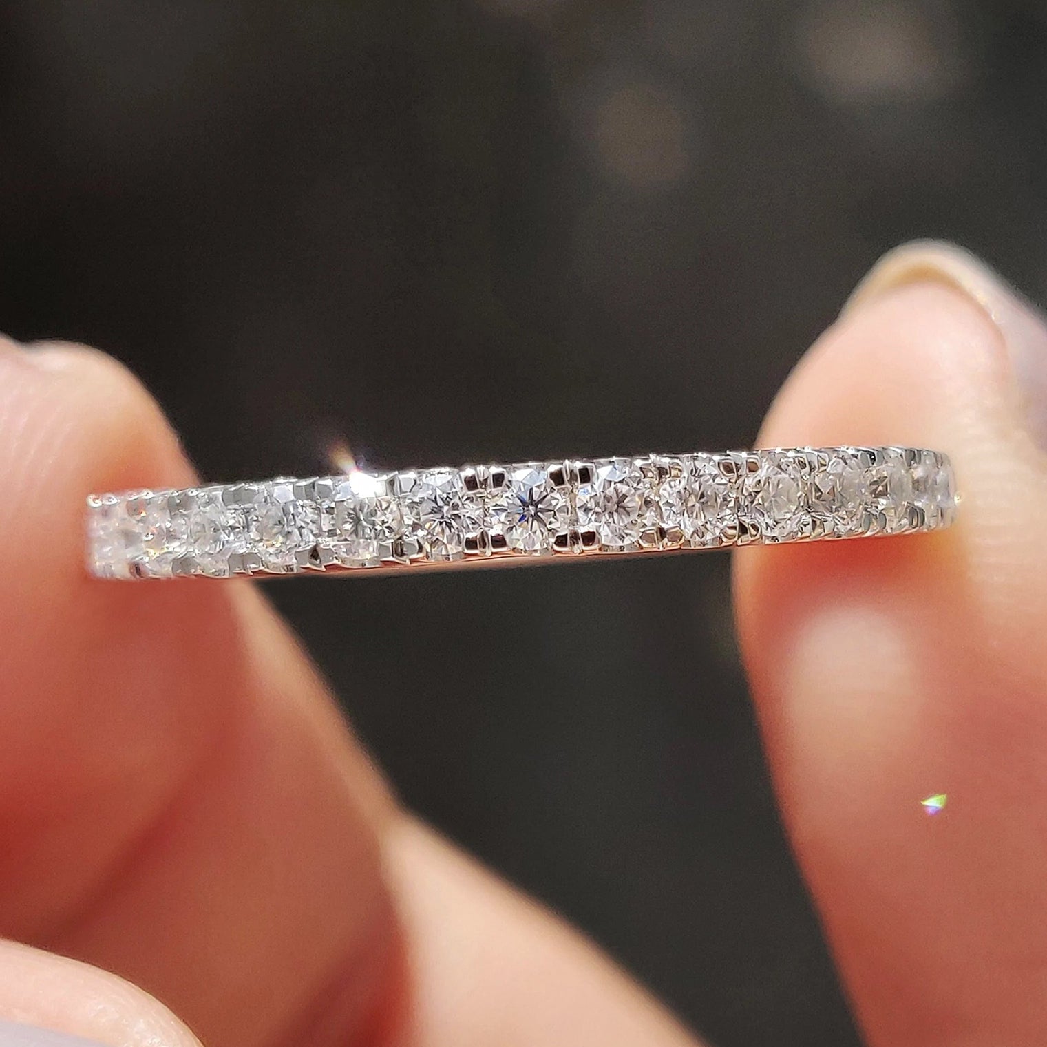 White gold moissanite wedding band pairs with round moissanite wedding band.
