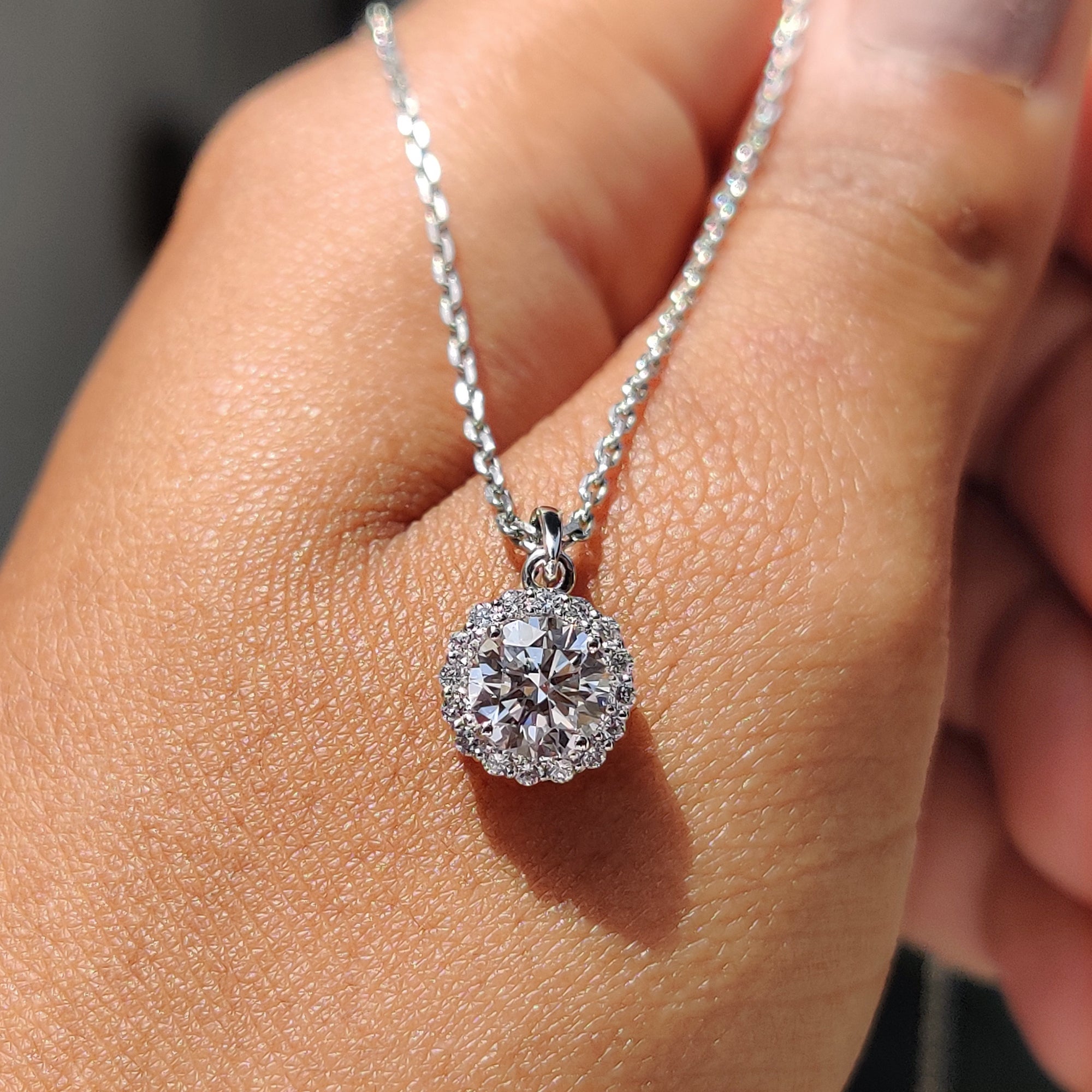 Unique diamond pendant with round diamond in halo design.
