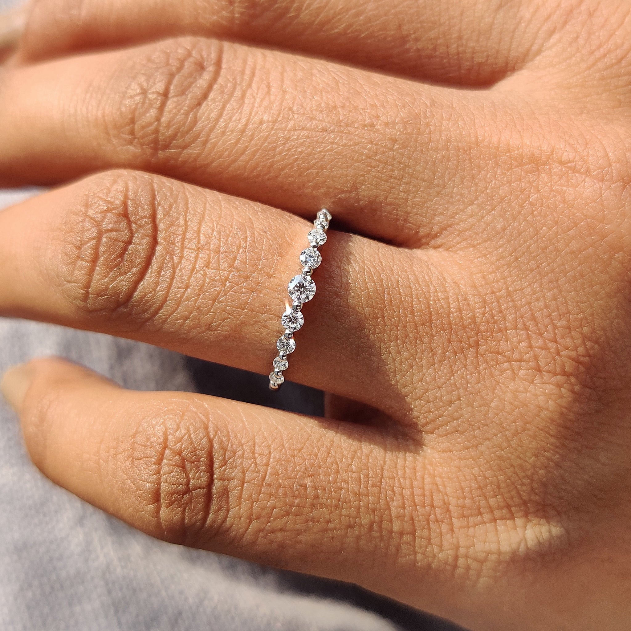 White gold wedding band with shared prong setting.

