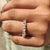 Half eternity wedding band designed with five oval moissanite stones in prong settings.