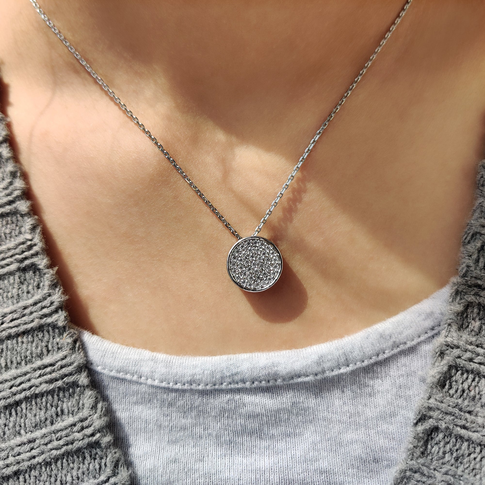 White gold pendant with round diamond cluster design.
