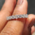 White Gold Wedding Band Women worn on a finger with soft background.
