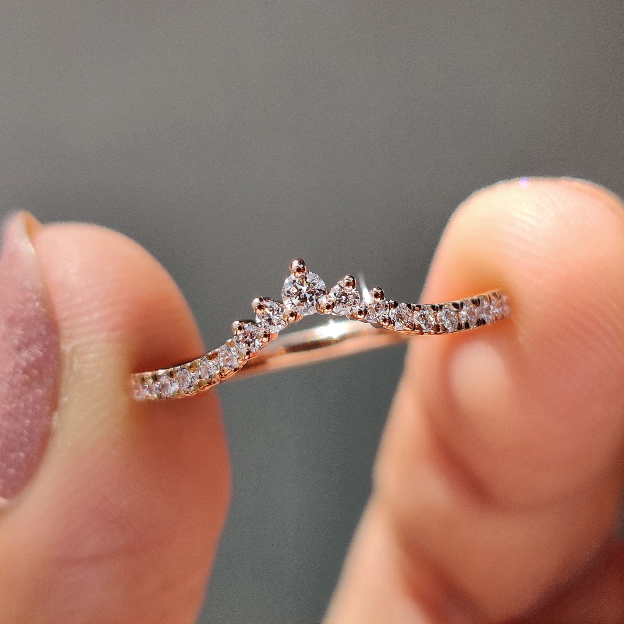 Chevron diamond wedding band displayed on a soft fabric background.
