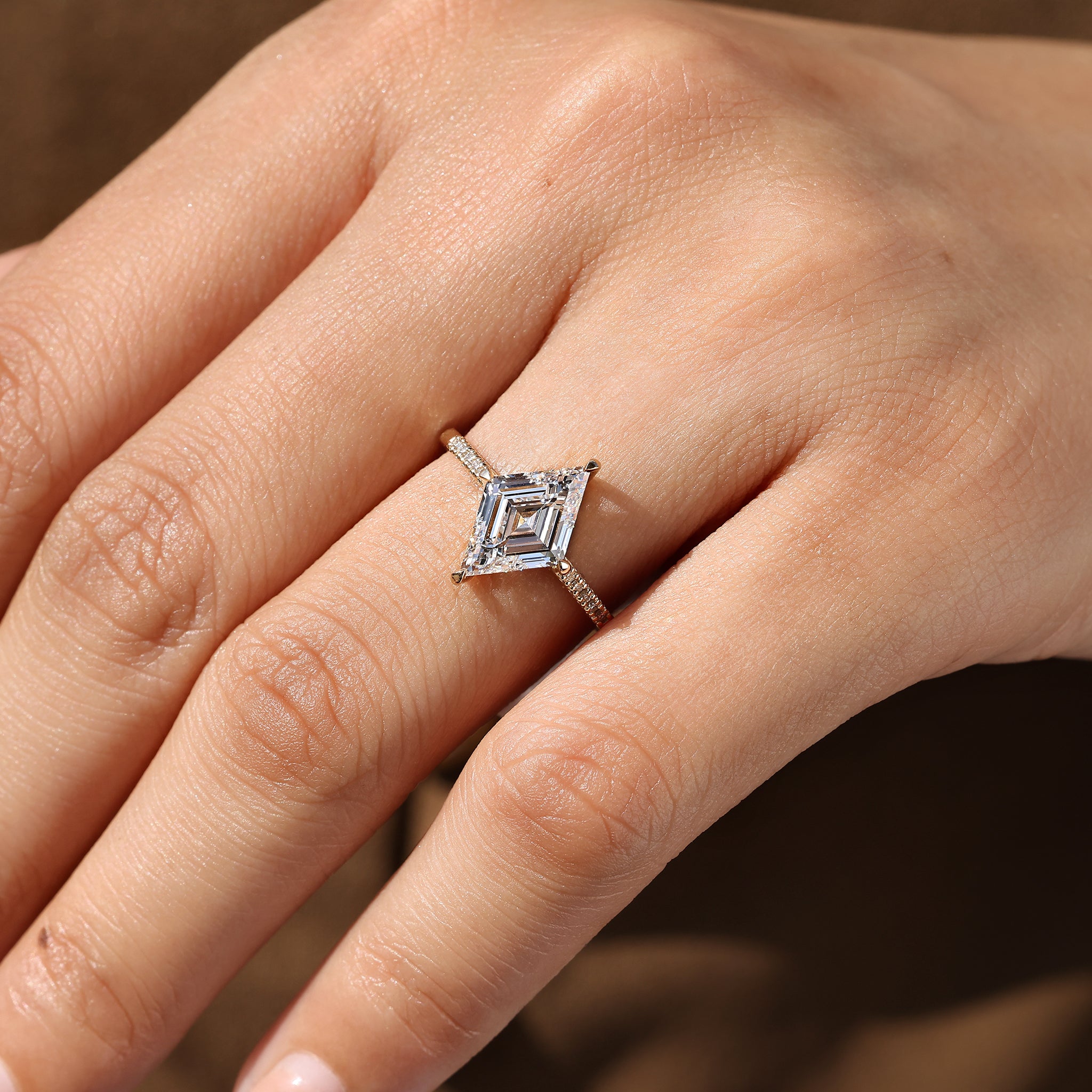 Lozenge cut diamond ring with round pave diamonds.