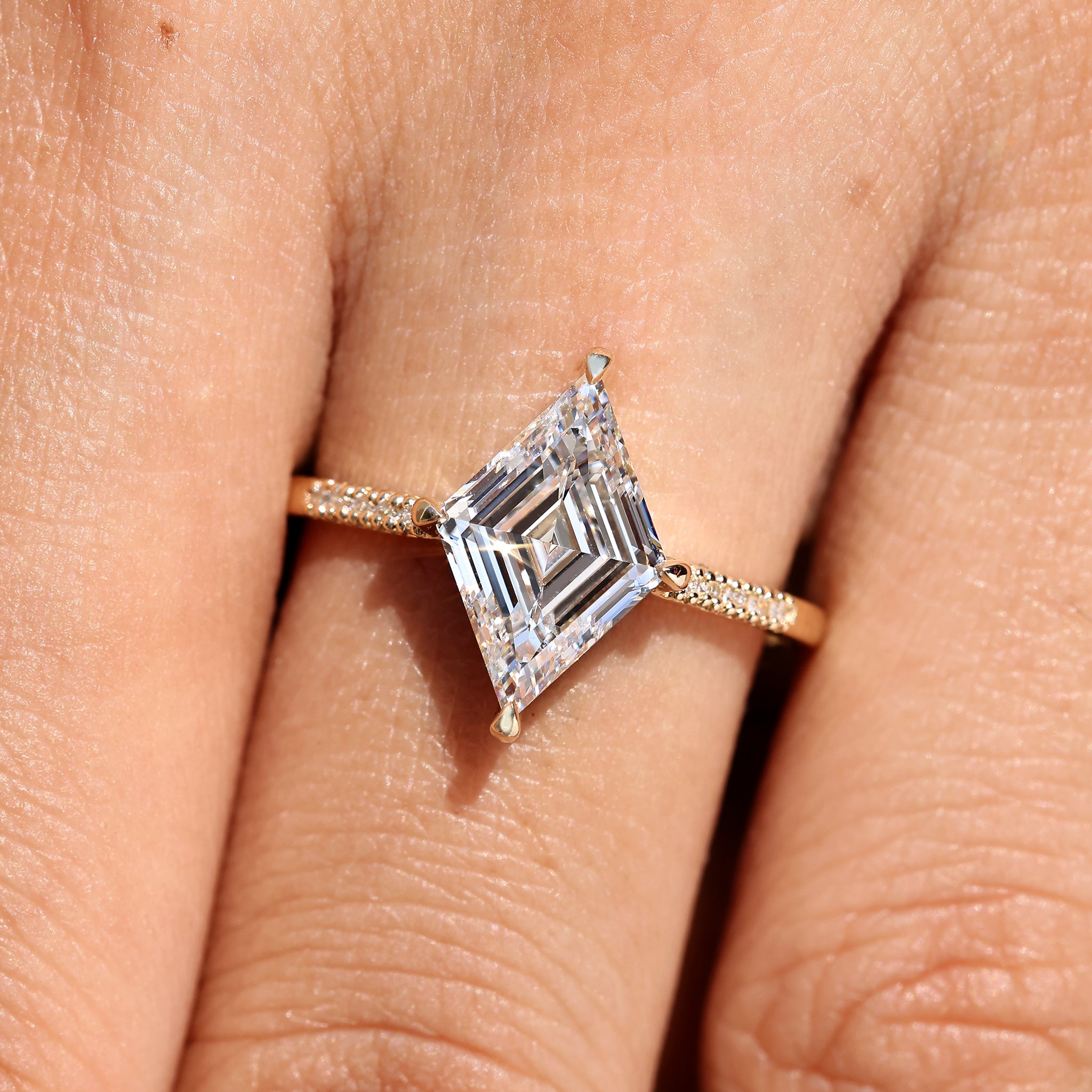 Lozenge cut diamond ring with pave style band.
