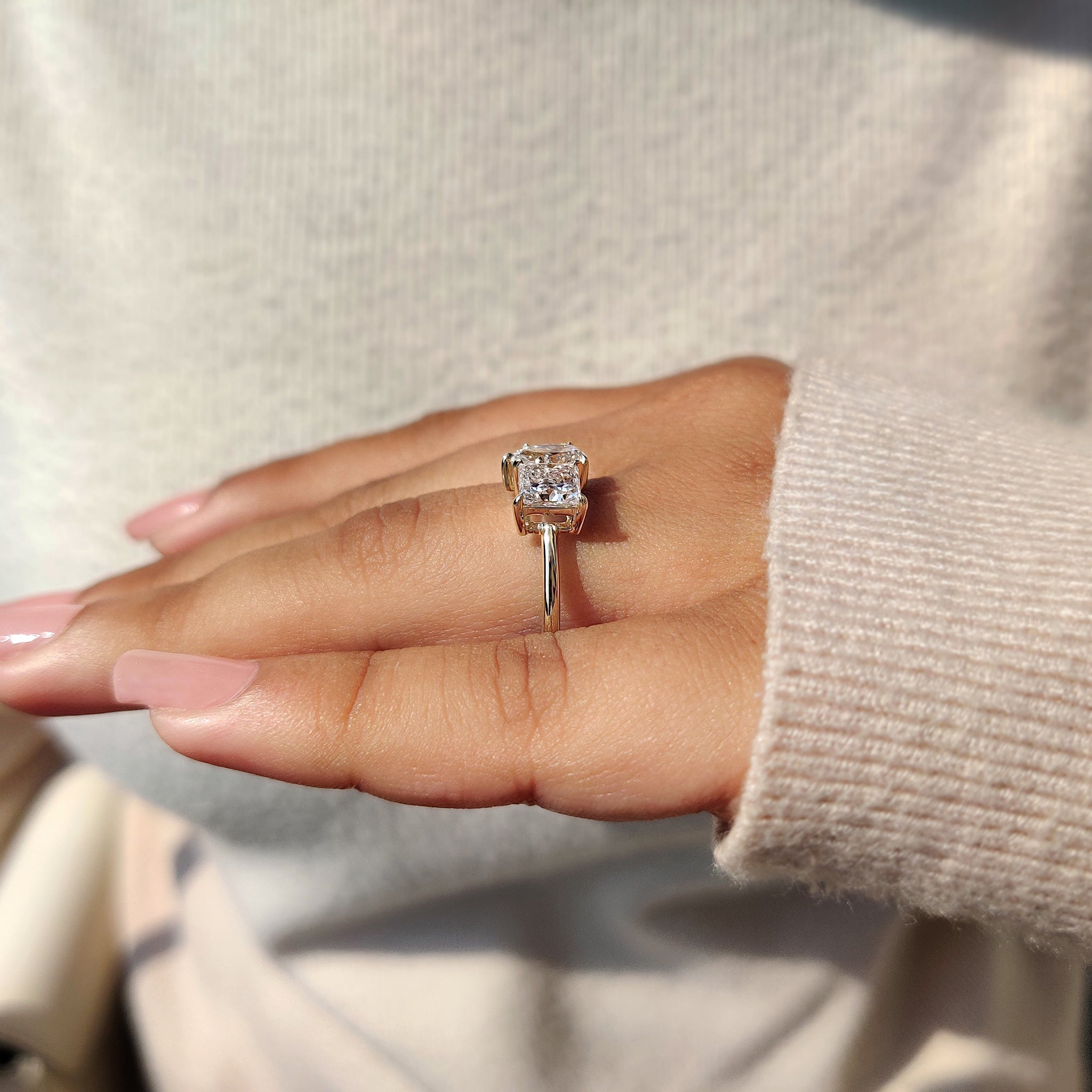 A custom engagement ring designed with a yellow gold band and igi certified lab-grown diamonds, including a princess cut and pear cut design.
