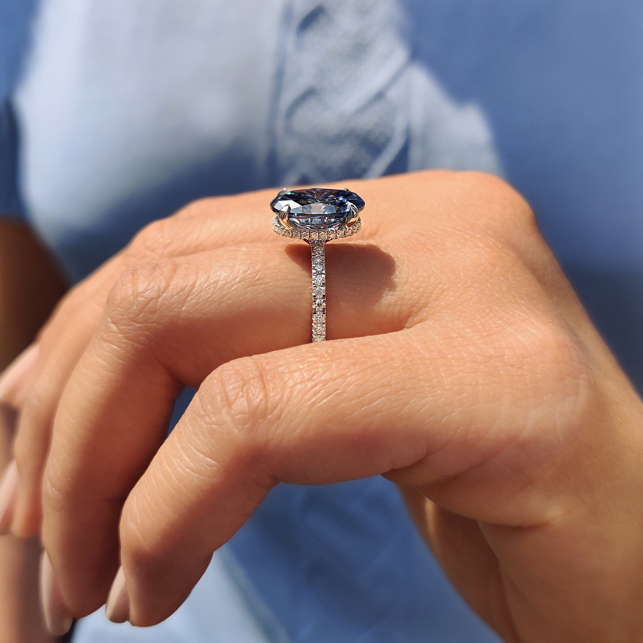 Best place to buy an engagement ring featuring oval cut royal dark blue Moissanite with round cut pave band.
