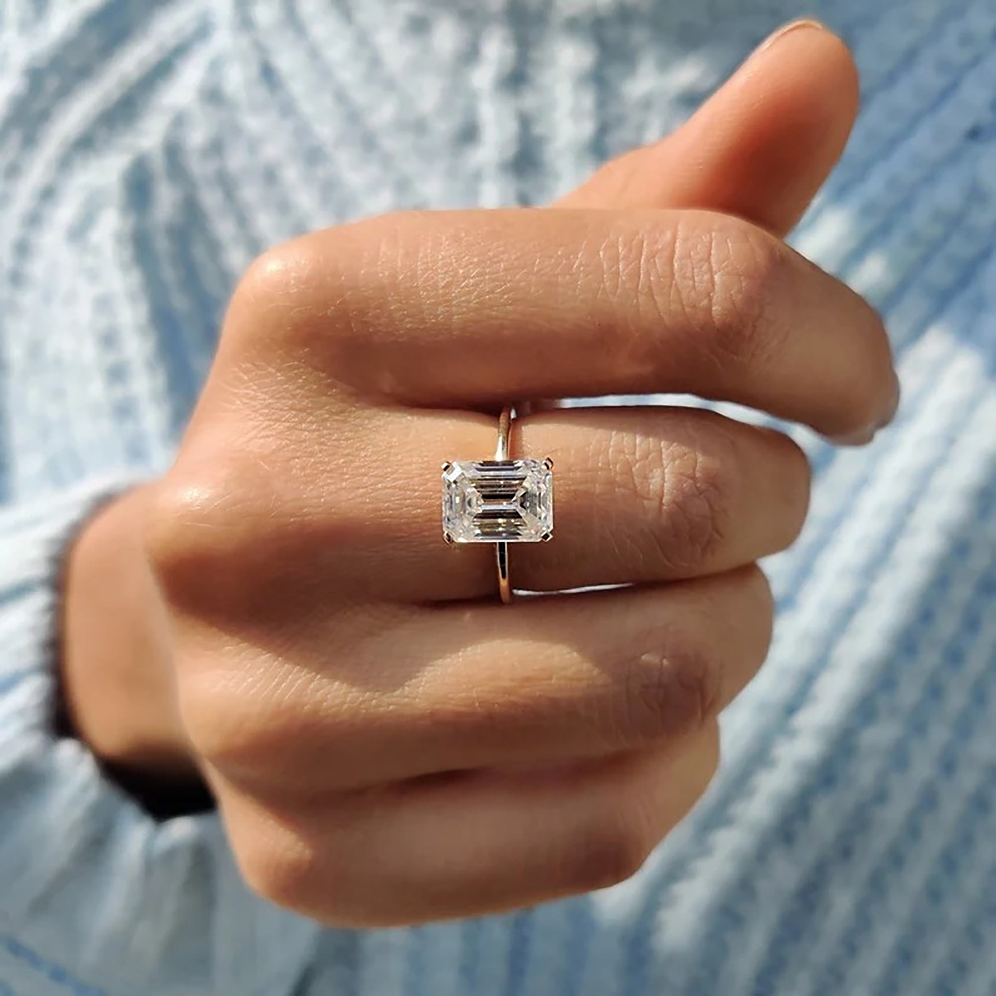 Knife edge ring featuring emerald cut center stone.
