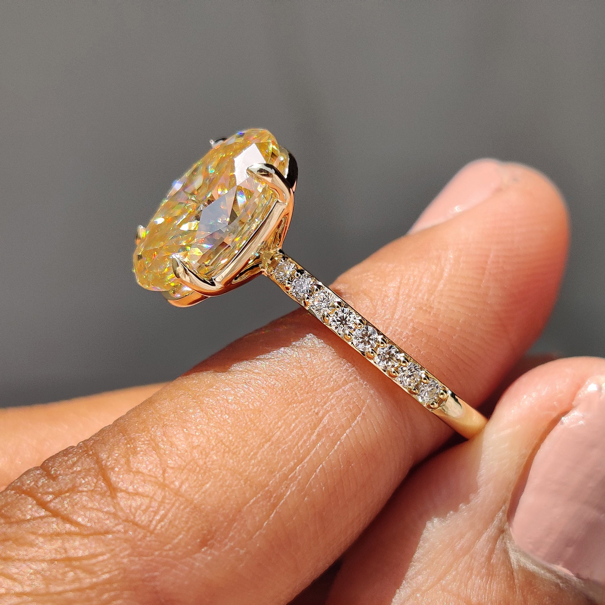 Buy engagement ring with a yellow gold band and oval cut Moissanite center stone for elegance.