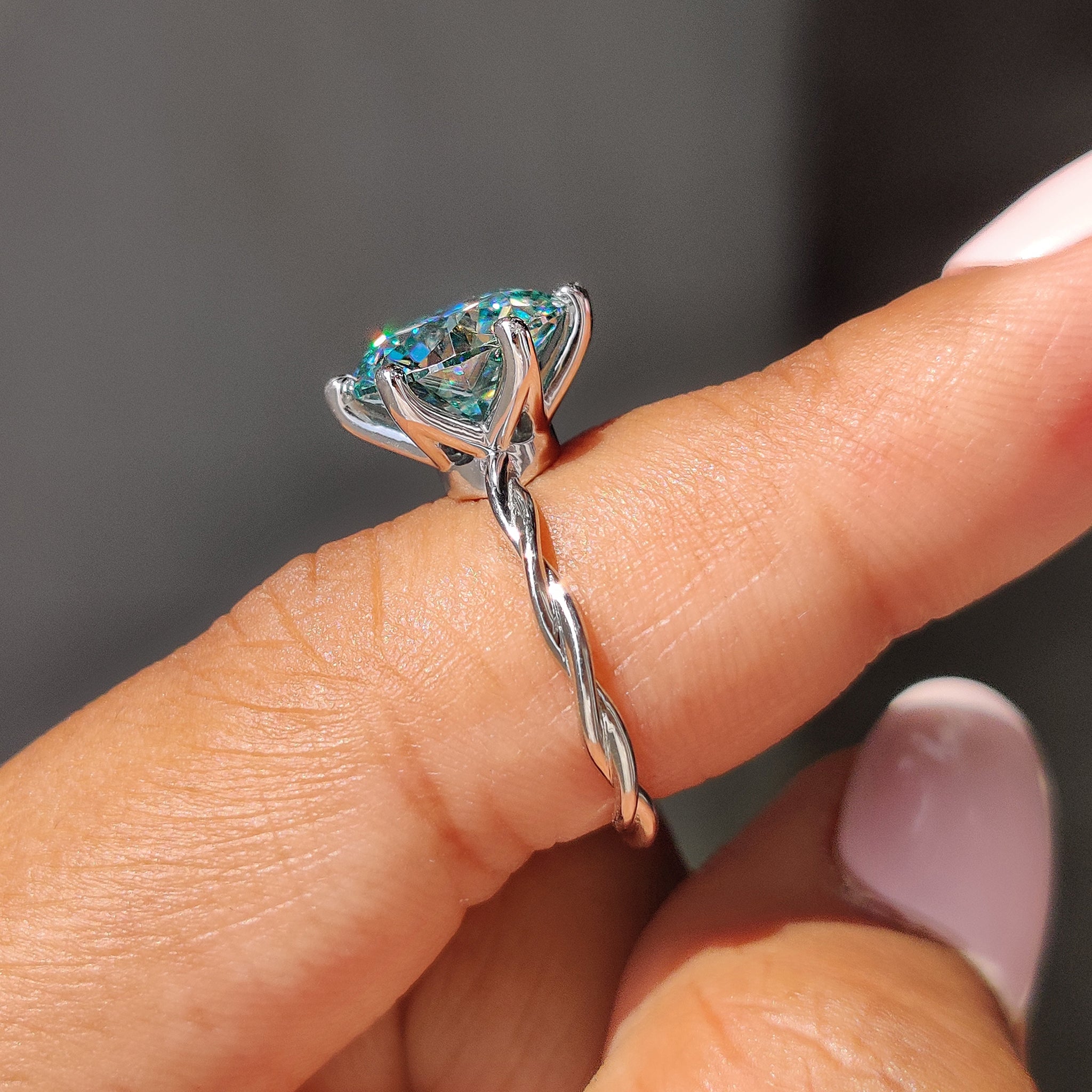 Cyan blue moissanite ring set in a 6 prong engagement ring style.
