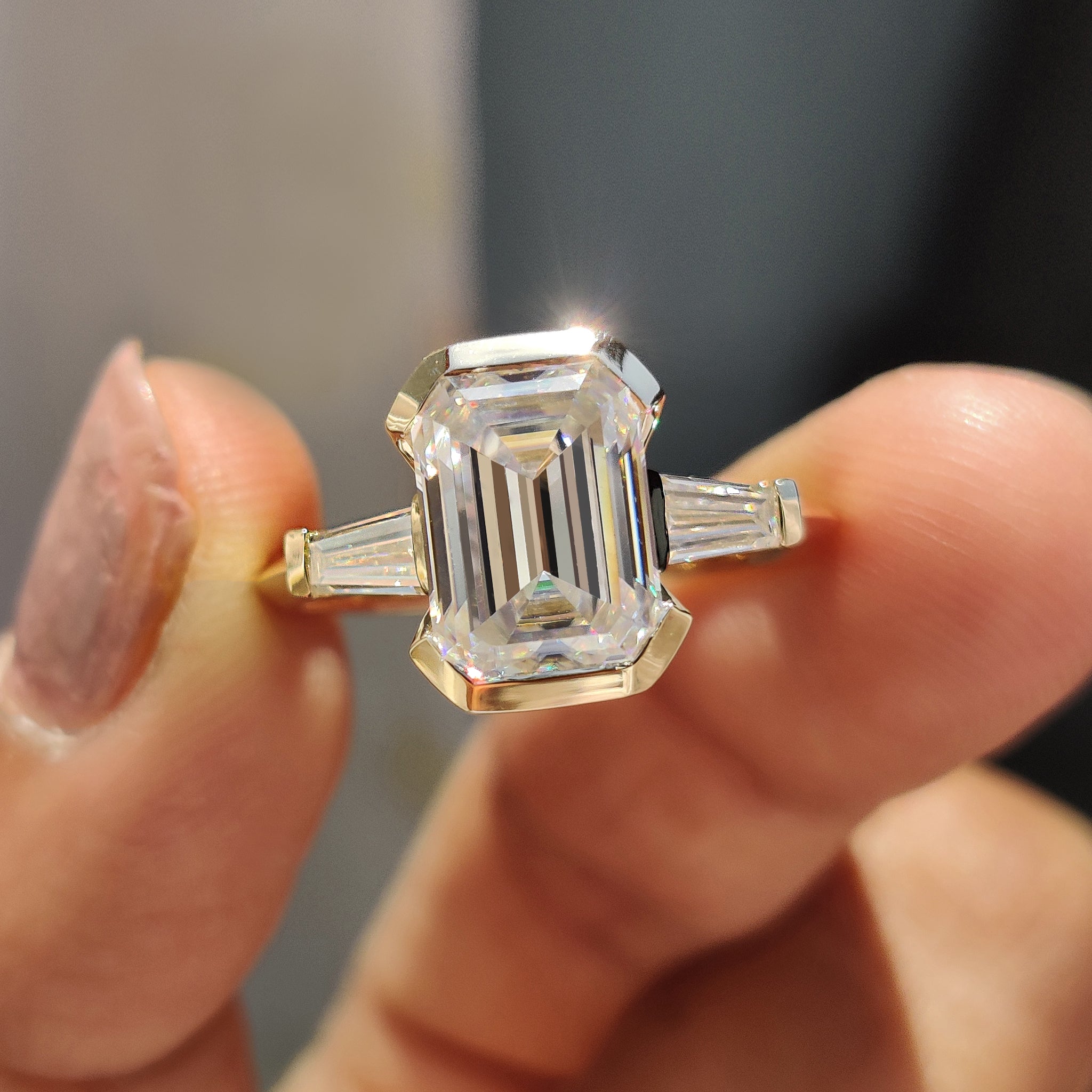 Emerald cut engagement ring with three stone design