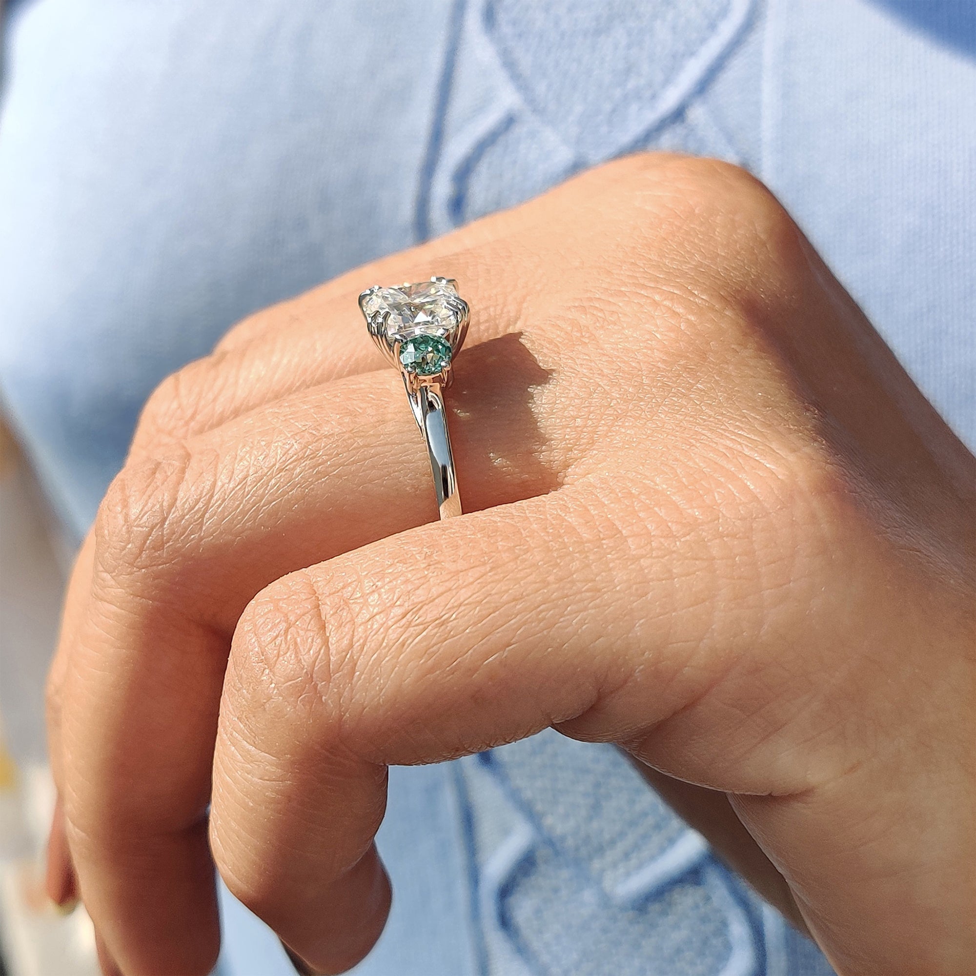 Moissanite proposal ring with green side stones.