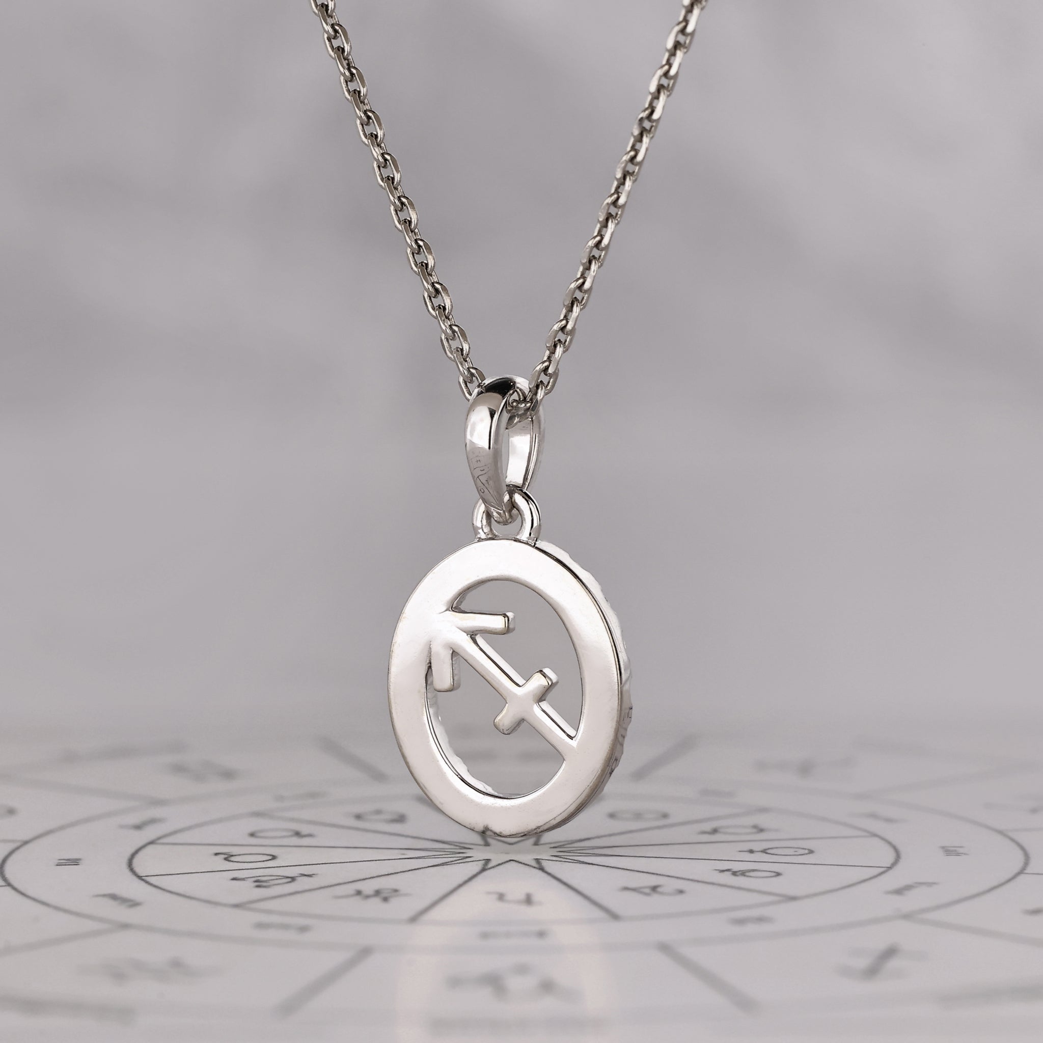 White gold Sagittarius pendant highlighting a halo diamond and zodiac sign.