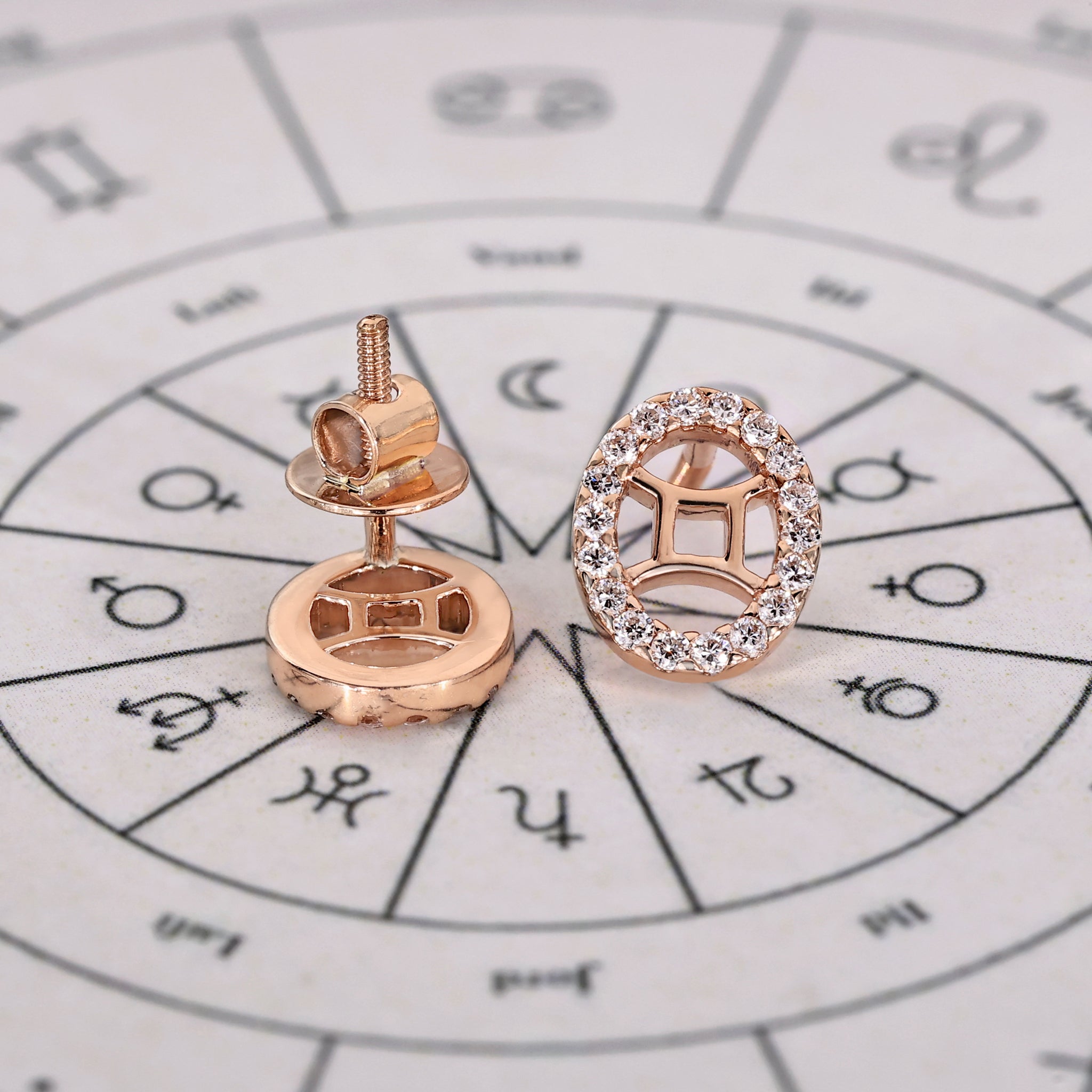 Astrology earrings featuring Gemini symbol with halo diamonds.
