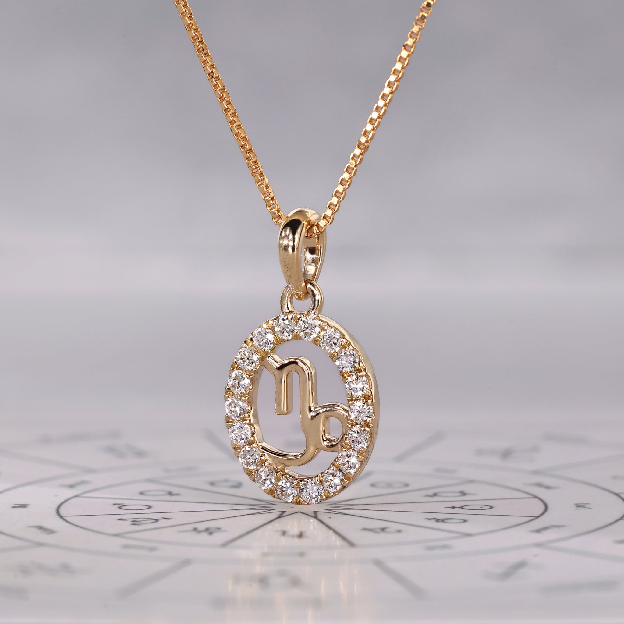 Featuring a round cut halo, this Capricorn gold pendant showcases the zodiac constellation.