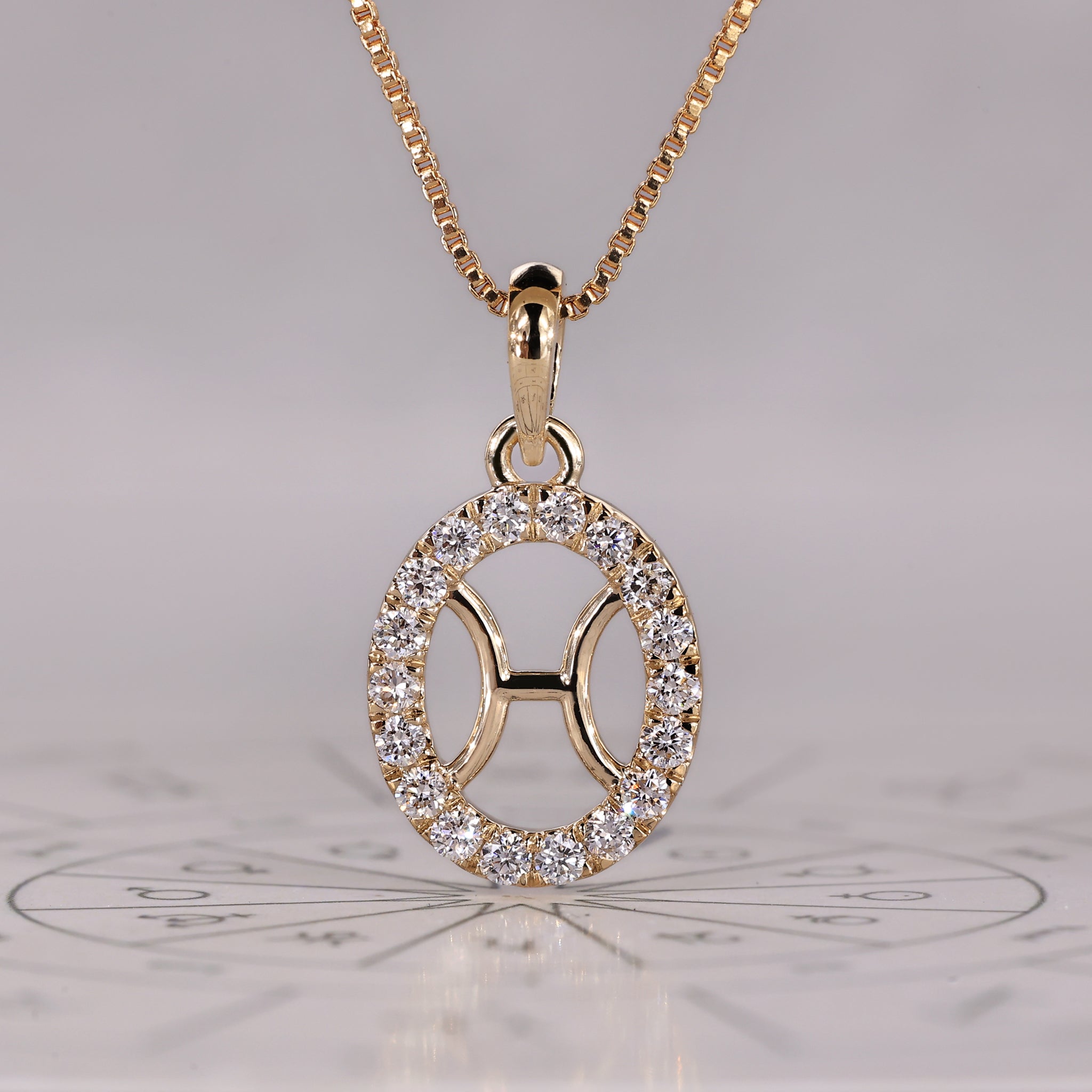 Pisces pendant in yellow gold with halo diamond design from Carat Diamonds.