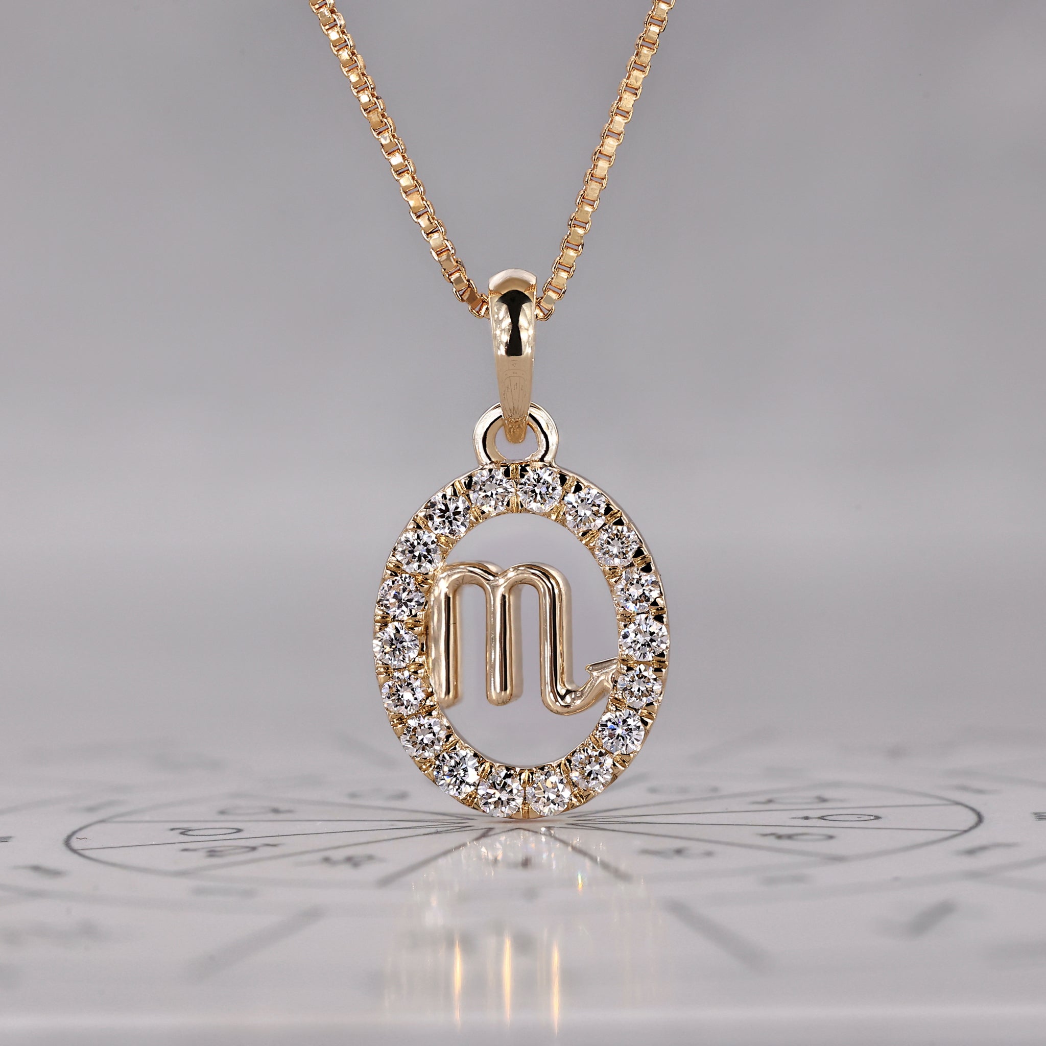 Gold Scorpio pendant with halo diamond and round cut design.