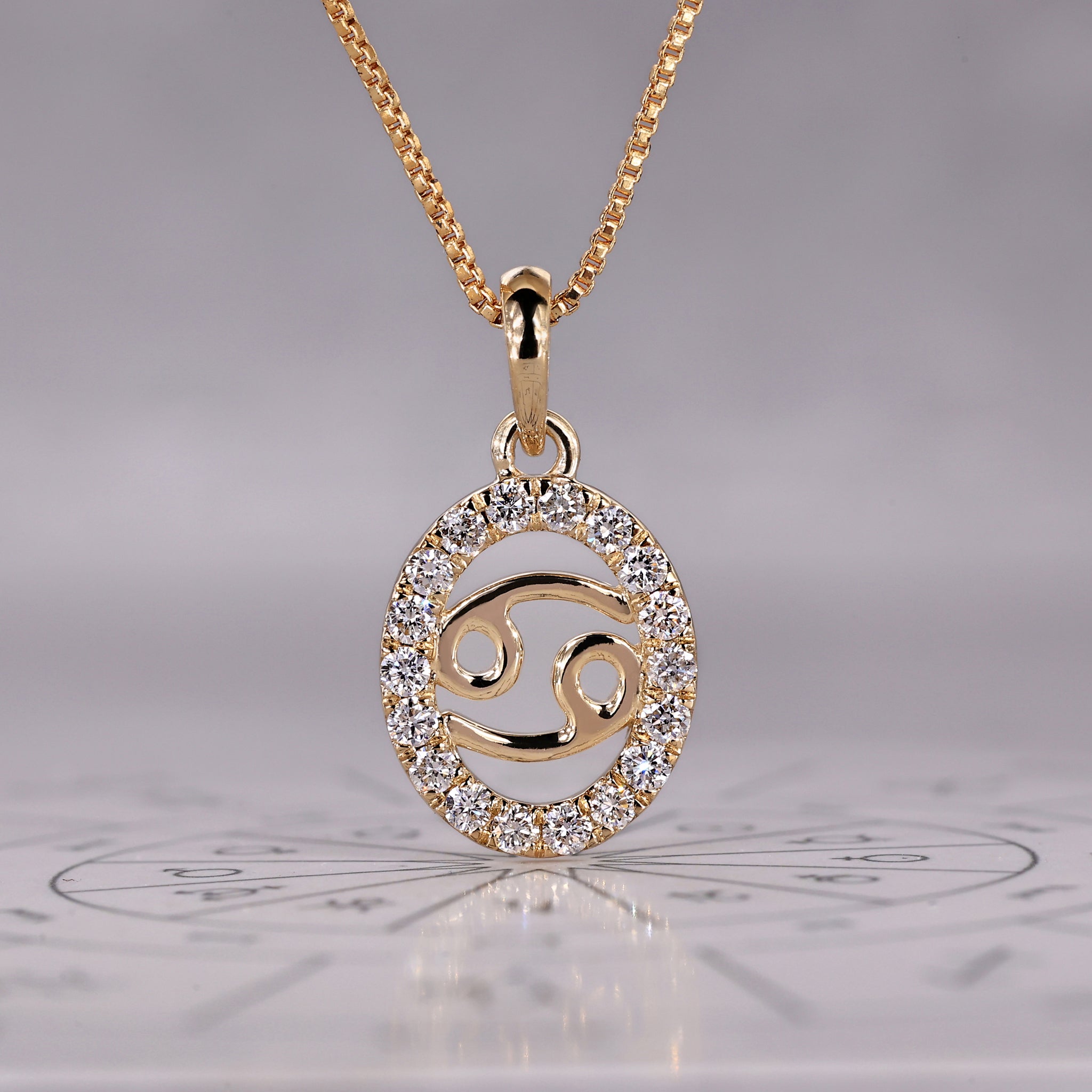 Gold Cancer pendant with halo diamond and round cut design.