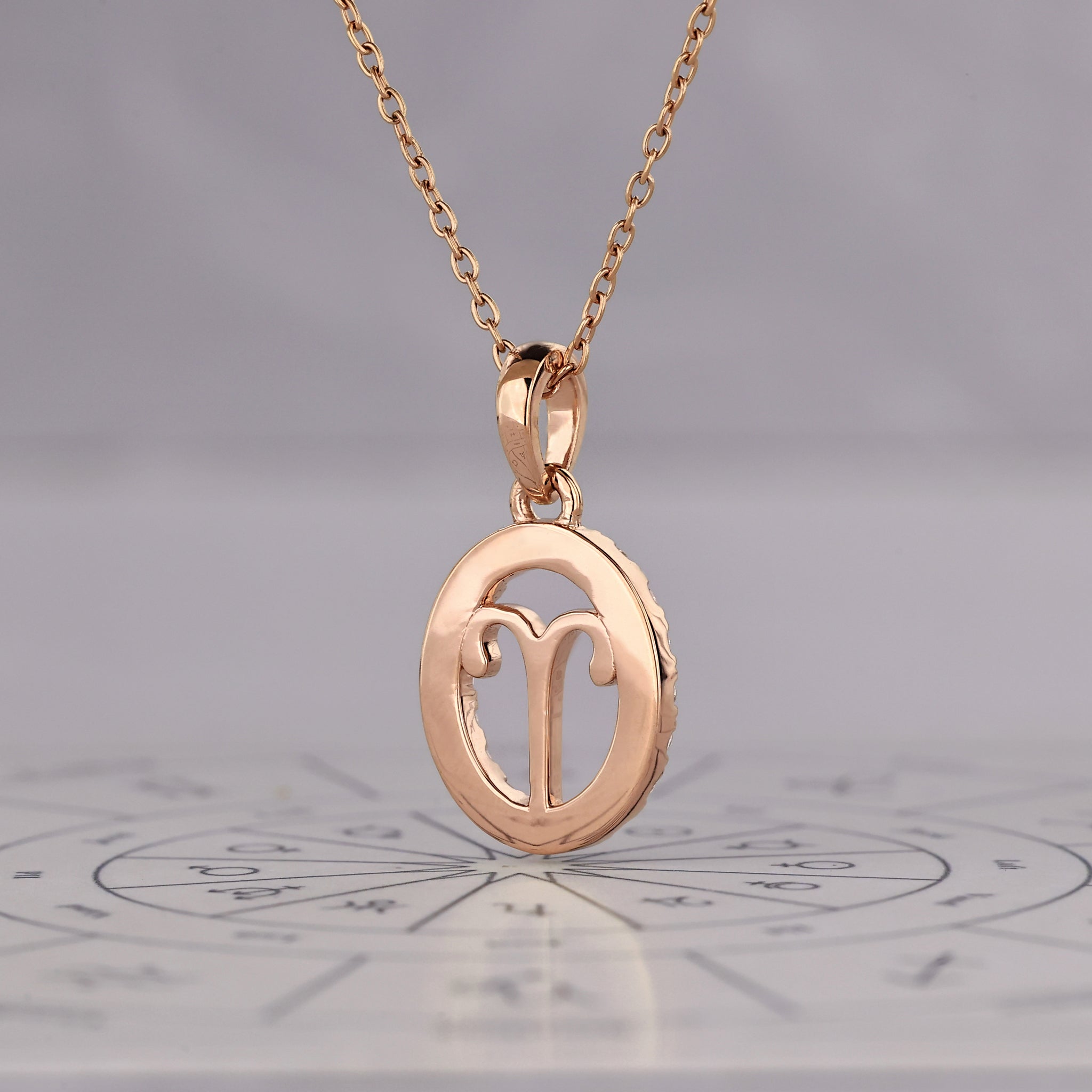 Aries pendant in gold with round diamond halo detailing.