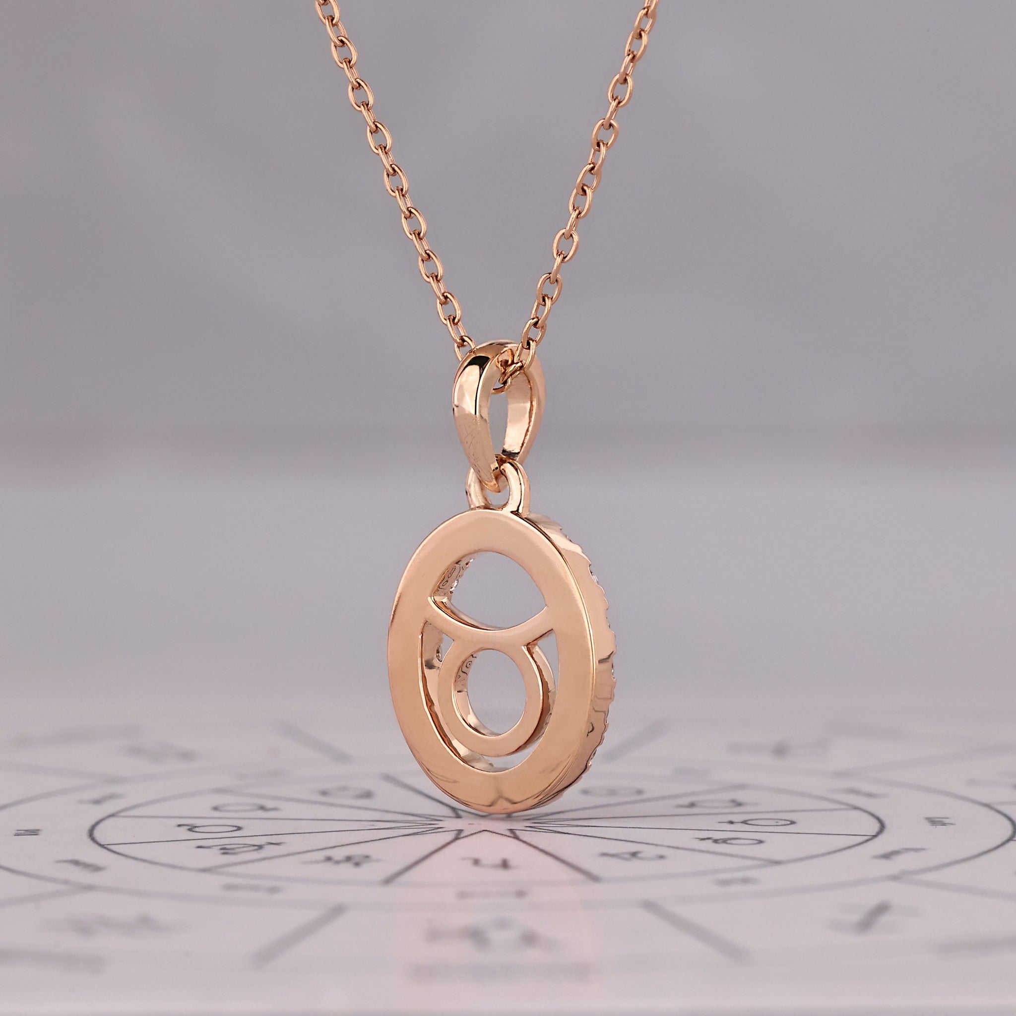 Carat Diamonds Taurus zodiac pendant in rose gold with halo diamond setting.