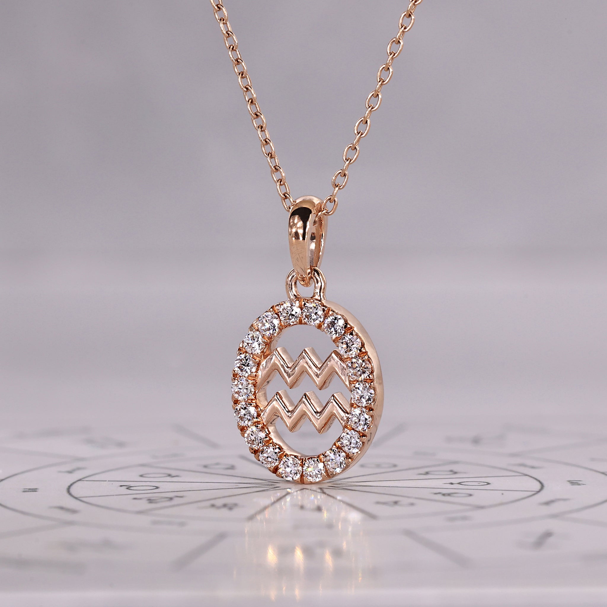 Carat Diamonds Aquarius zodiac pendant in gold with halo diamond setting.