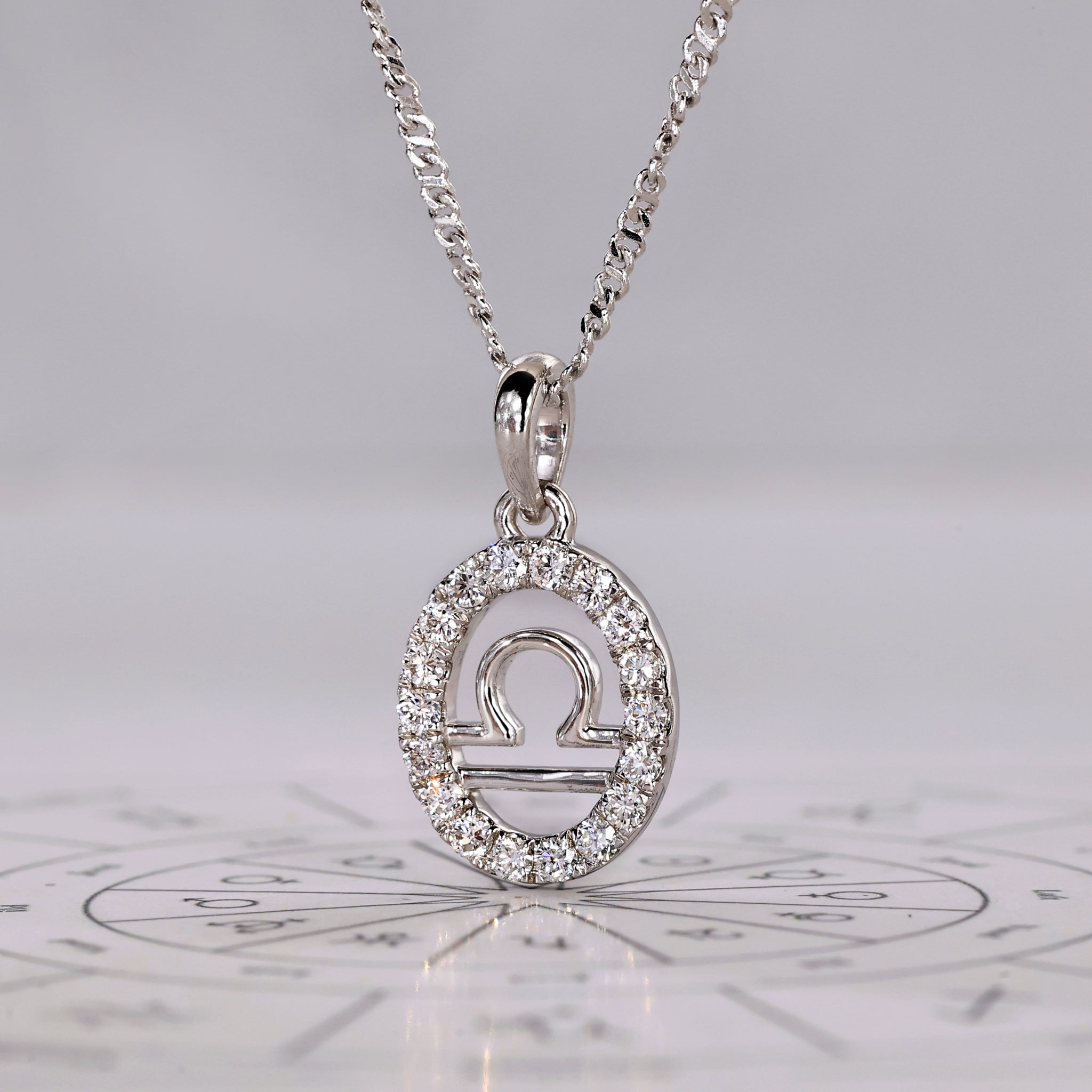 Handmade horoscope pendant for Libra in gold with diamond accents.