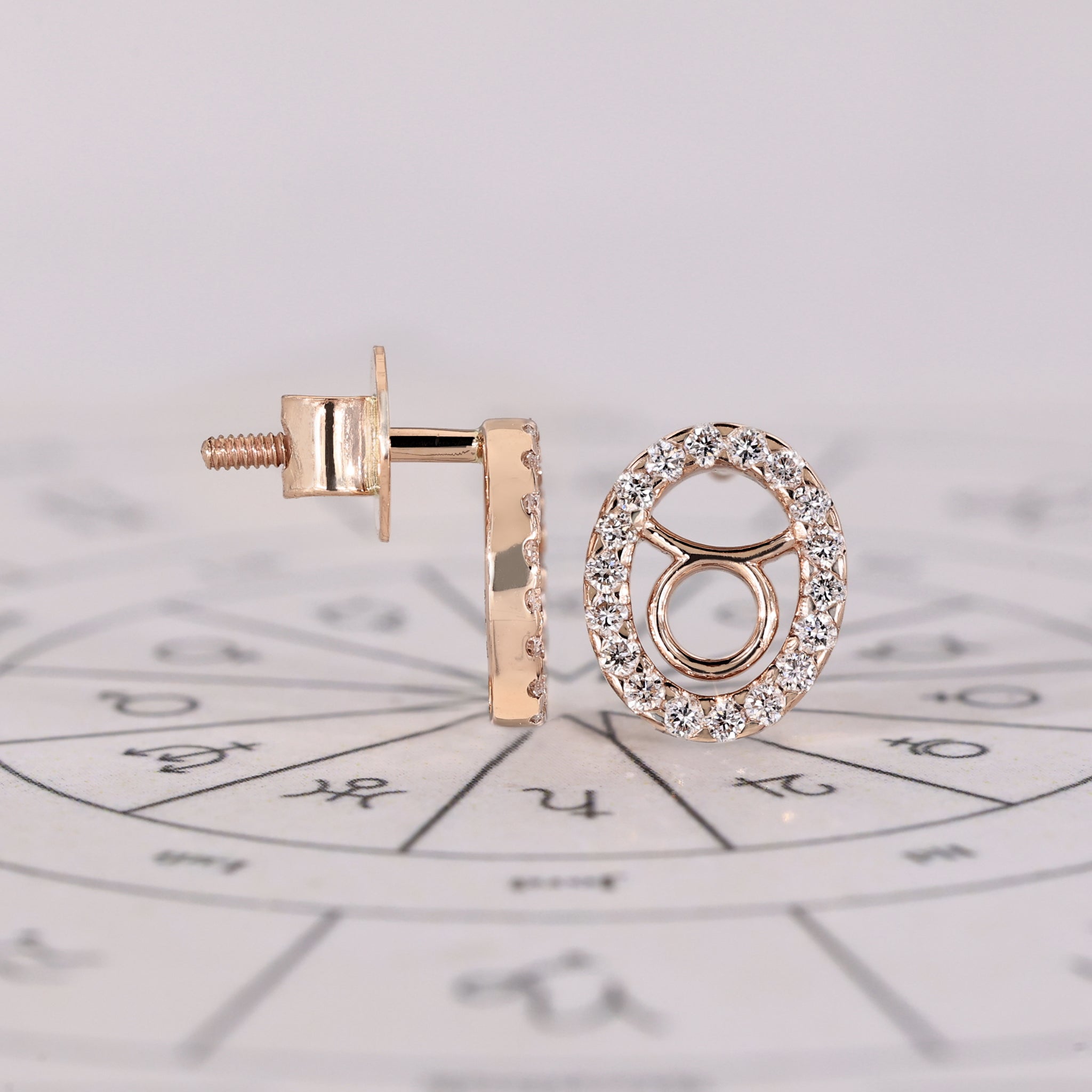 Custom Taurus zodiac earrings in rose gold with halo diamonds.
