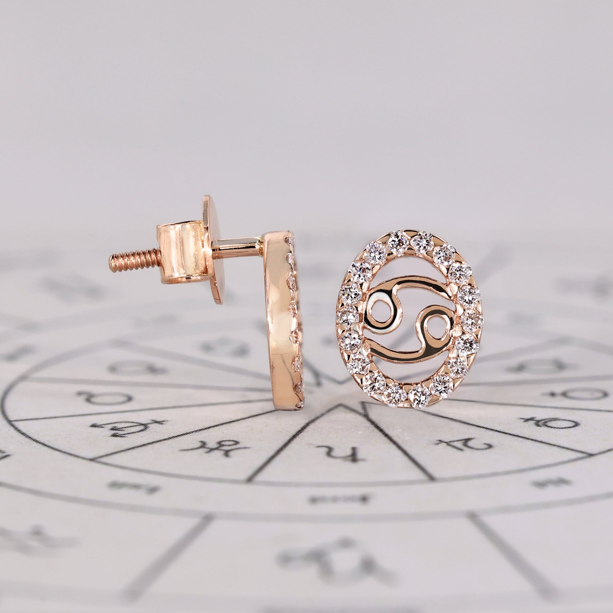 Custom Cancer zodiac earrings in rose gold with halo diamonds.
