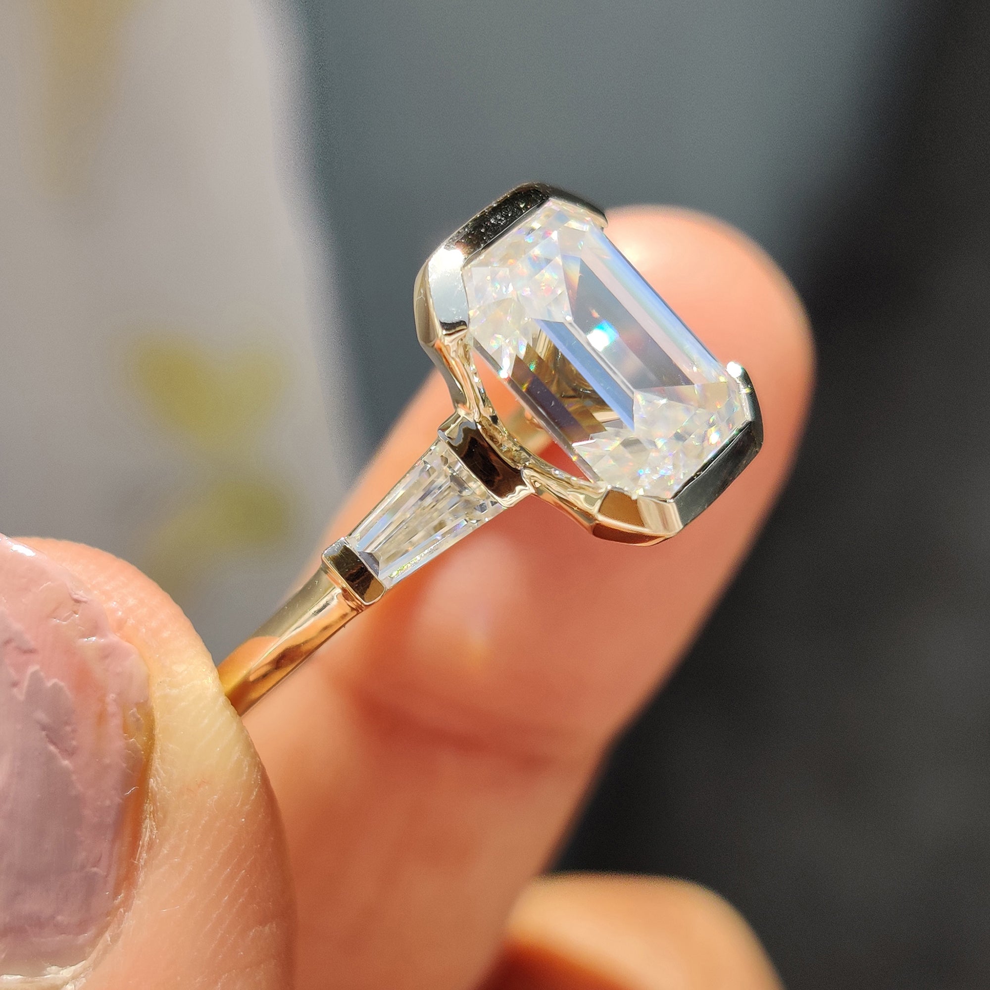 Elegant three stone emerald cut engagement ring