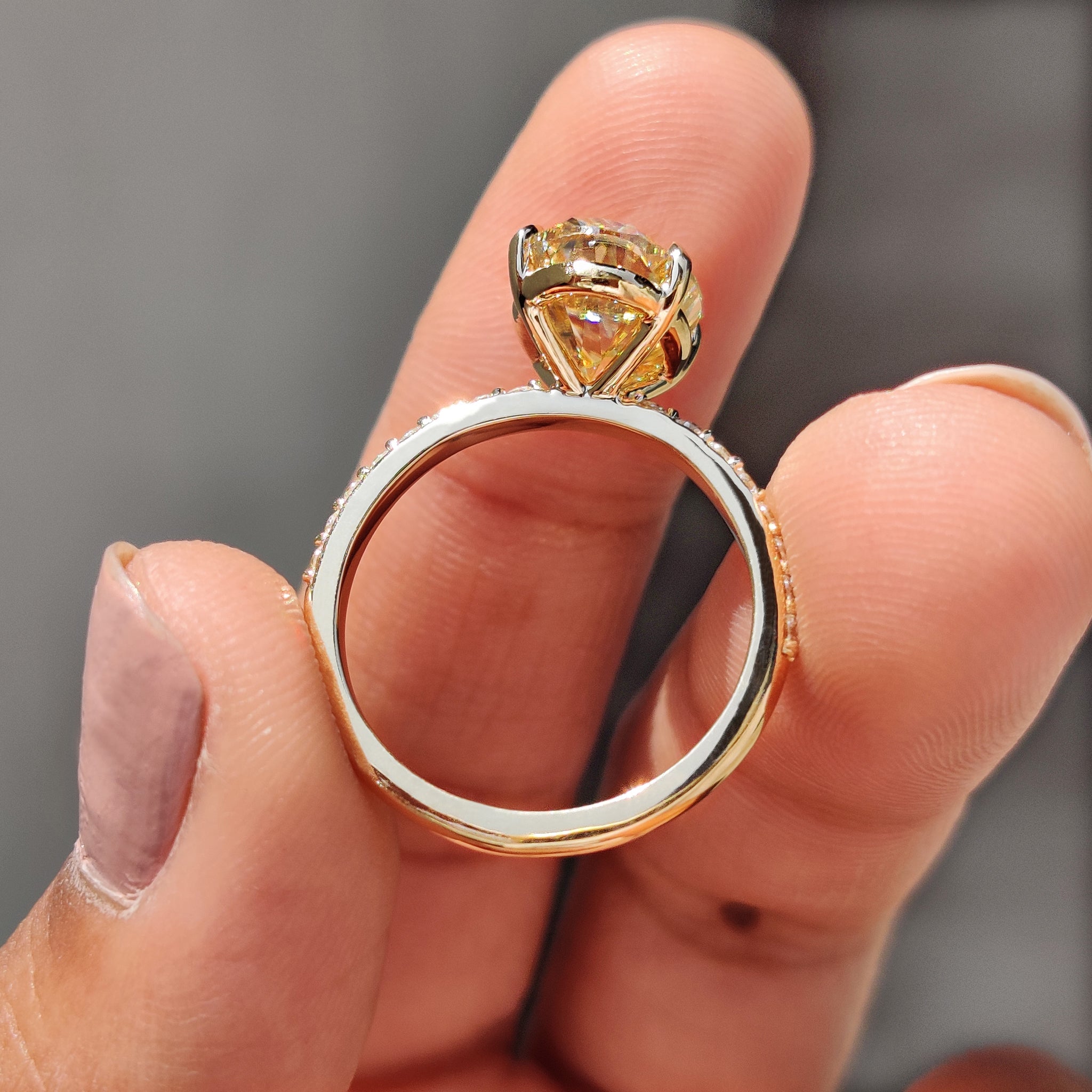 Yellow oval cut Moissanite center stone on a 4 claw prong setting, perfect for engagement.