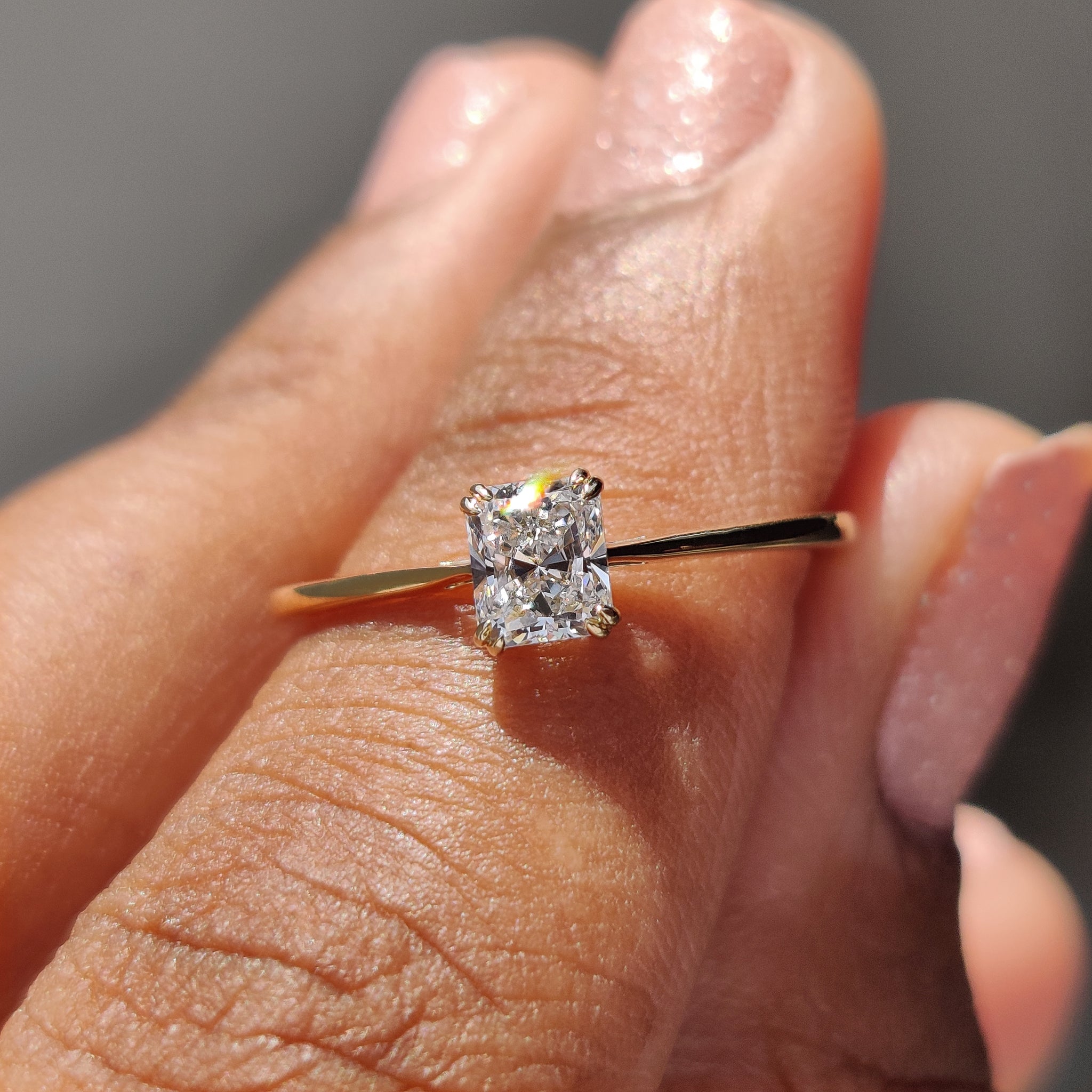 Handcrafted radiant cut diamond engagement ring in yellow gold.
