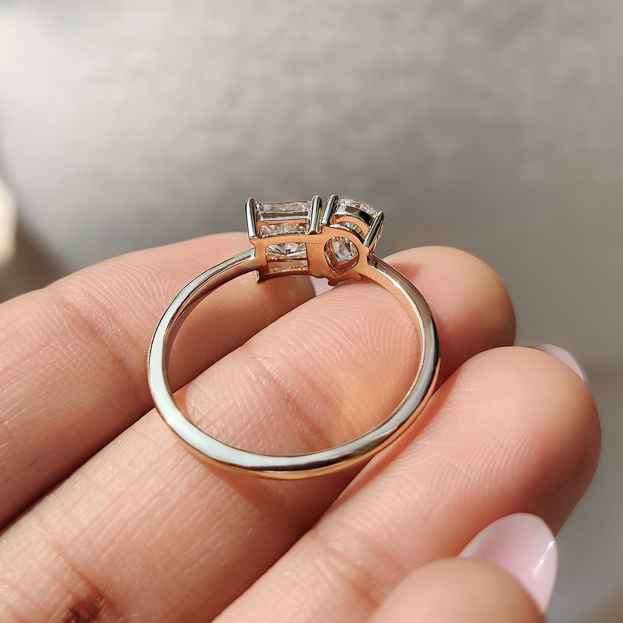 A carat diamonds engagement ring in a simple design, featuring lab-grown princess cut and pear cut diamonds in yellow gold.
