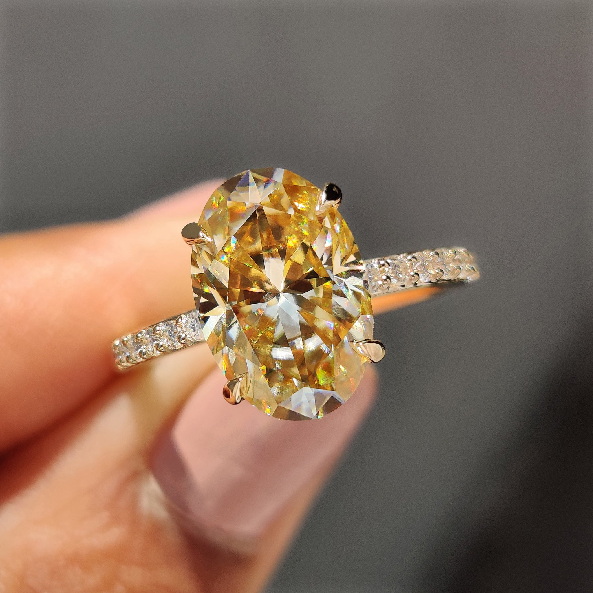 Oval Moissanite engagement ring set in yellow gold with a stunning pave setting band.