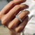 Shared prong wedding band with round moissanite stones set in white gold.