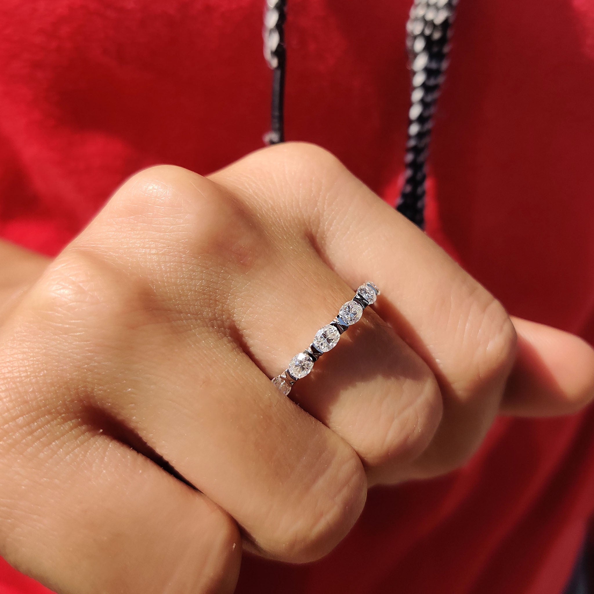 East West oval cut wedding band featuring side-set moissanite for a unique bridal look.
