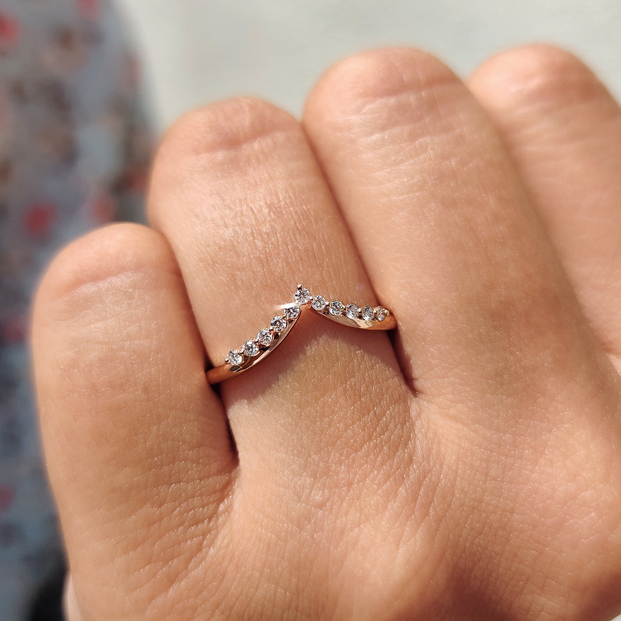 V shaped wedding band with round cut moissanite set in white gold.