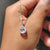 White gold diamond pendant featuring a round diamond halo.
