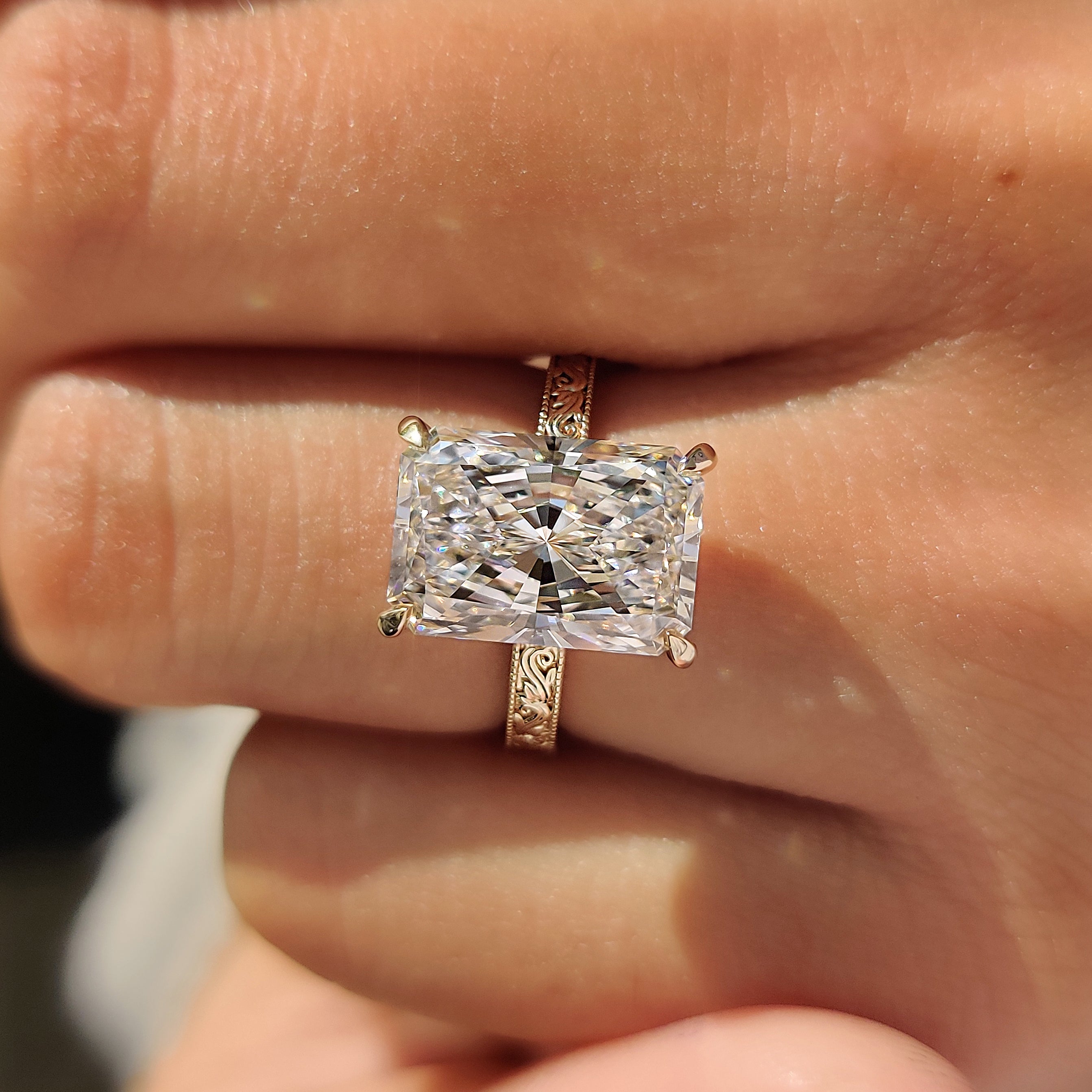 Radiant cut diamond ring with hidden halo detail.
