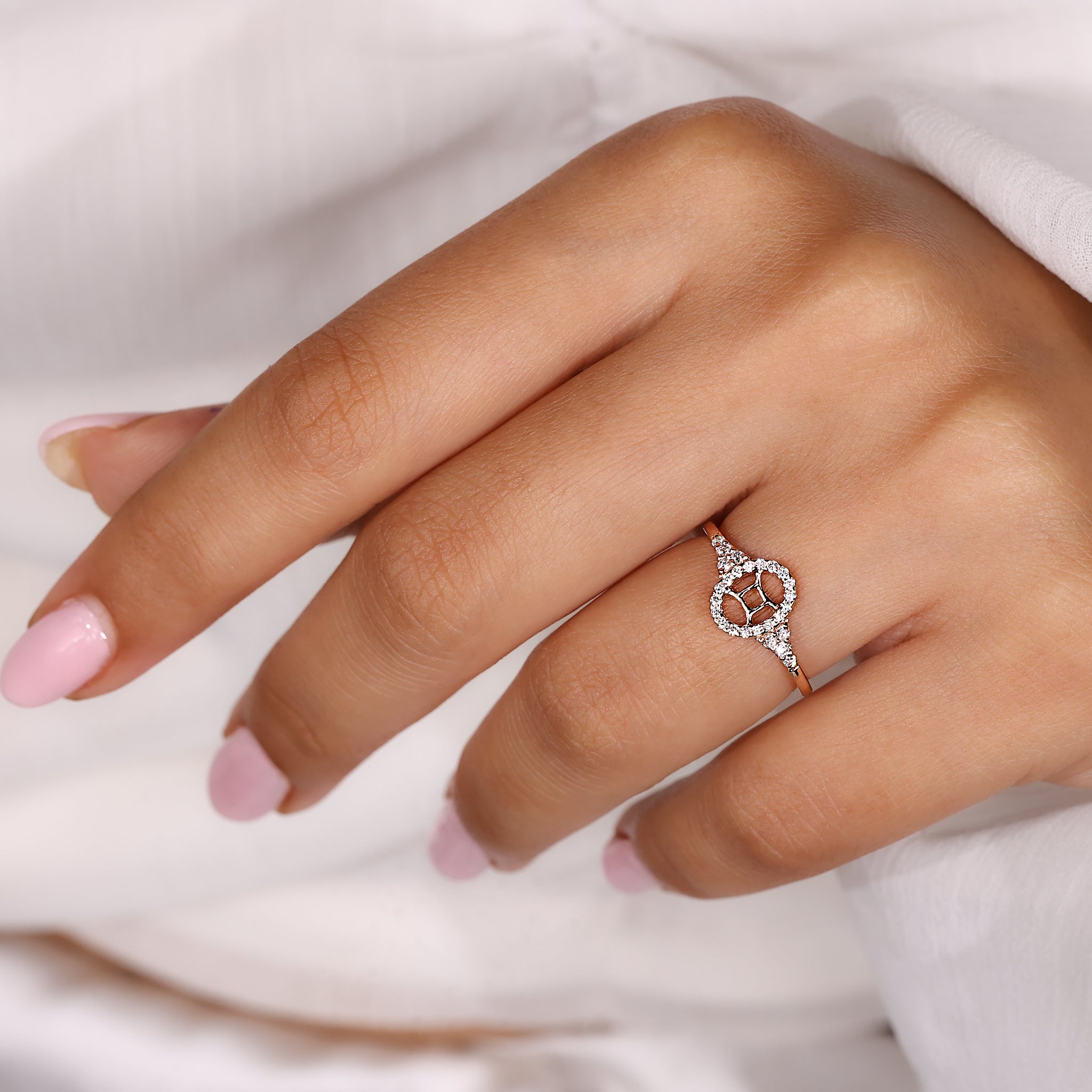 Carat Diamonds Gemini ring with halo diamond design in rose gold.
